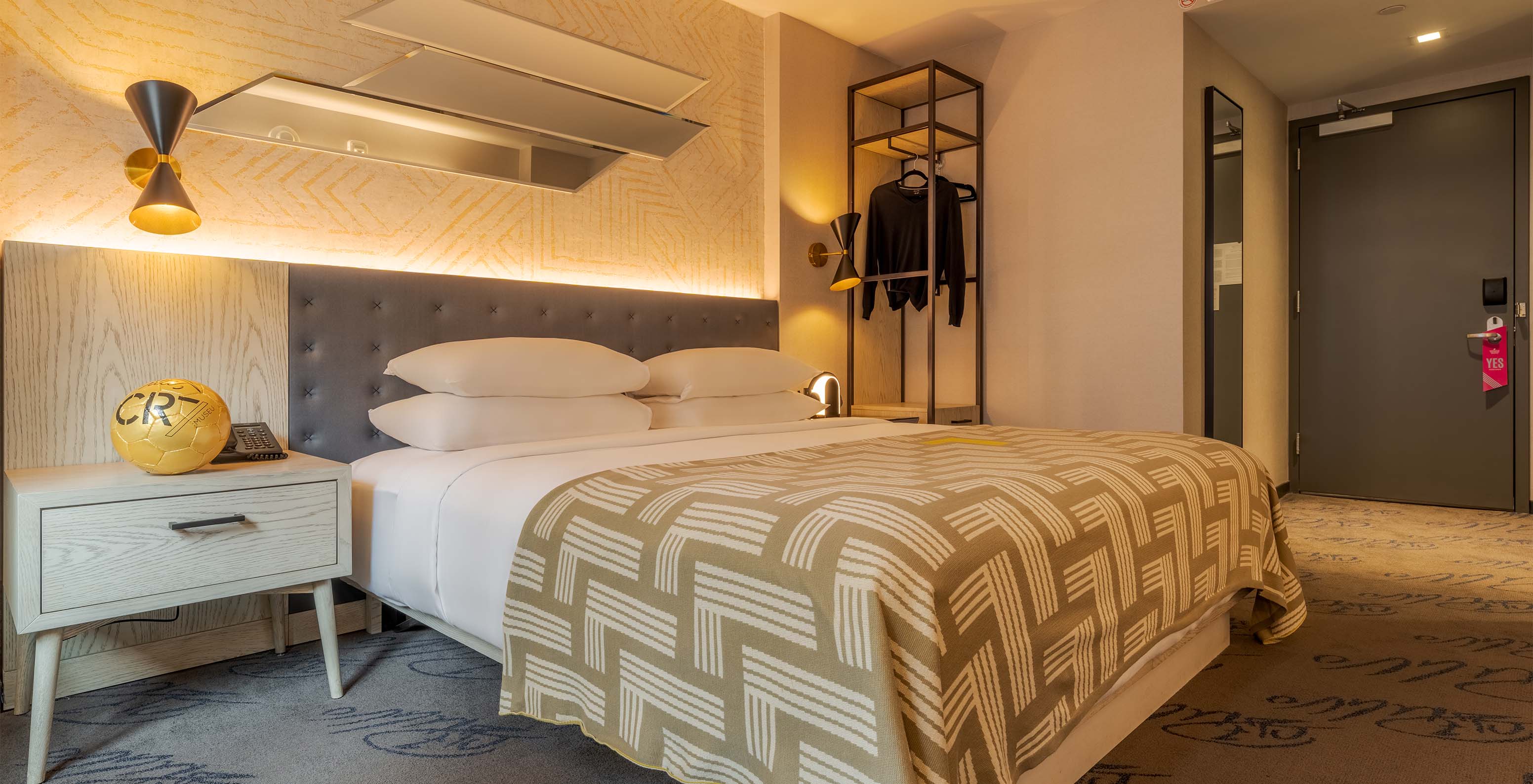 The Comfort ADA at Pestana CR7 Times Square has a double bed with a number seven quilt and a hanger