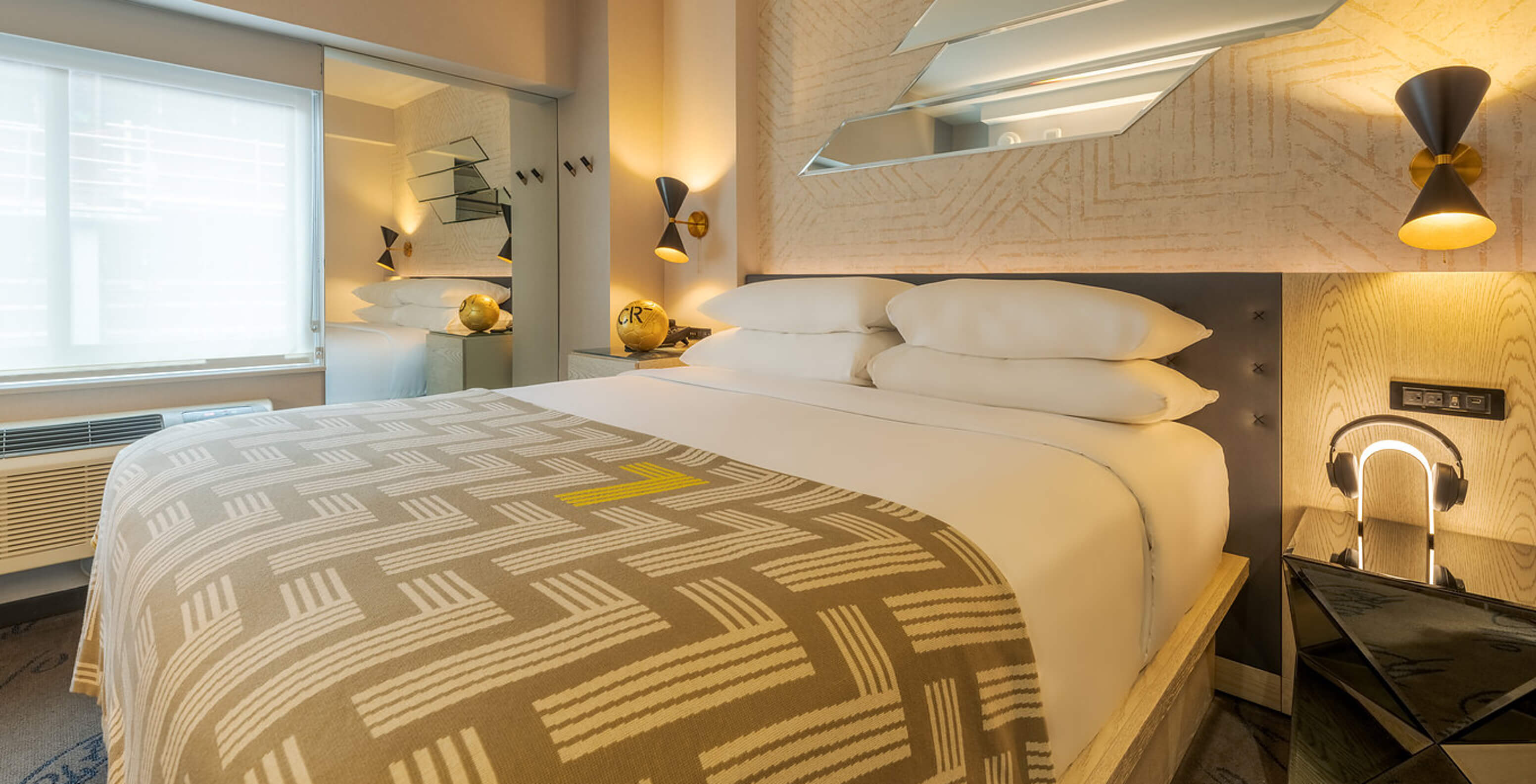 The Comfort ADA at Pestana CR7 Times Square has a double bed with a number seven quilt and a wardrobe