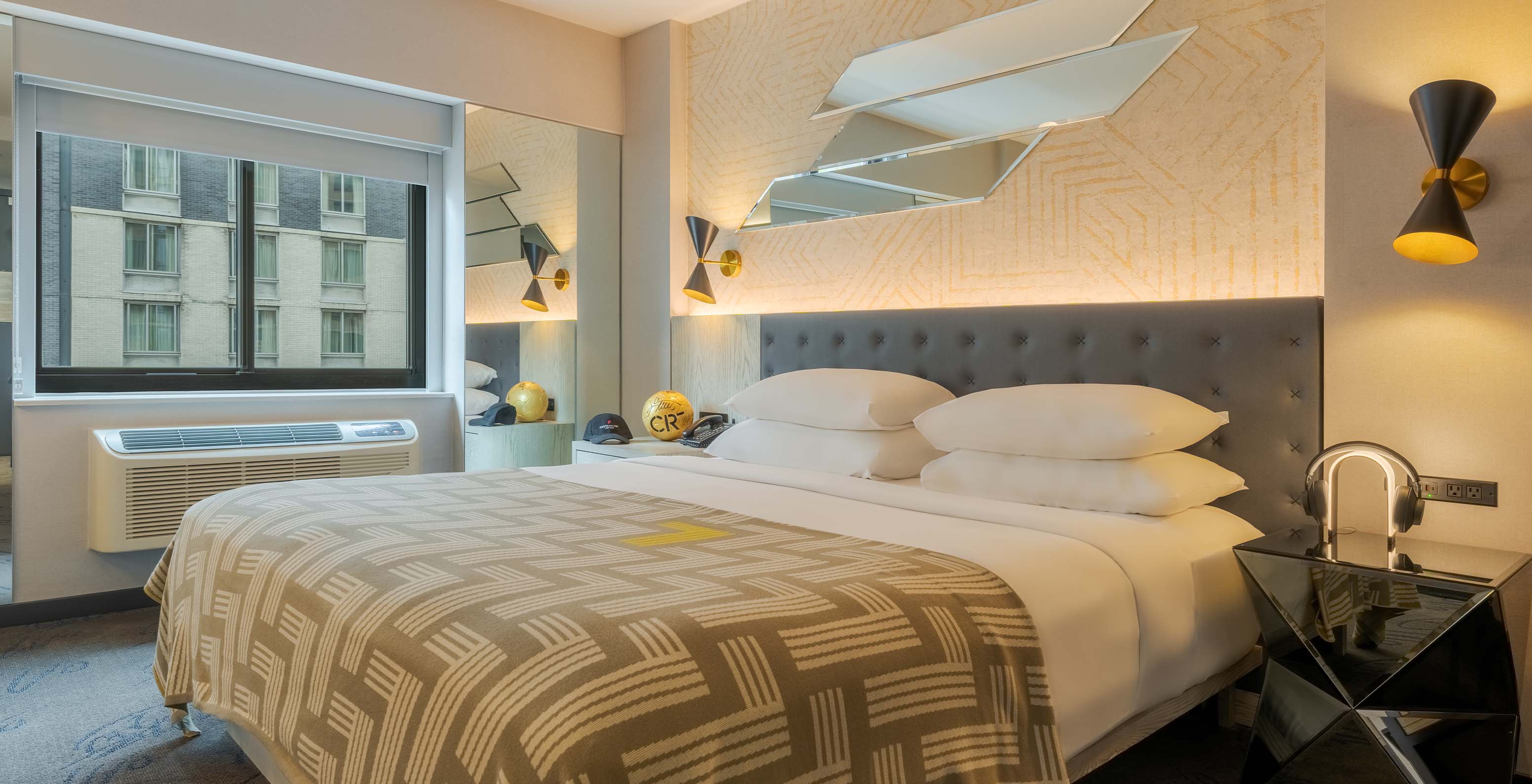 The Comfort at Pestana CR7 Times Square has a double bed with a bedspread with the number seven and a window