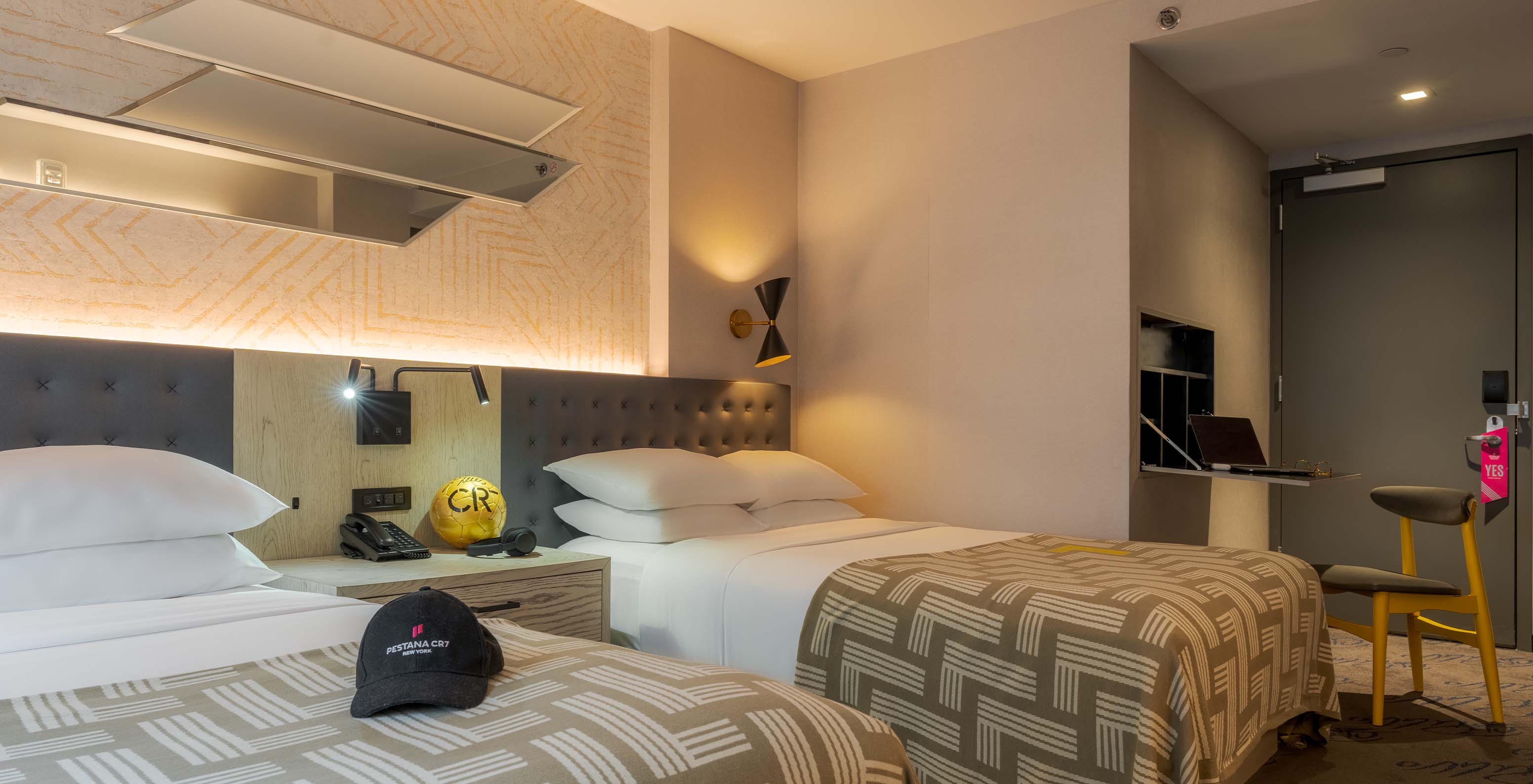 The Superior Double ADA at Pestana CR7 Times Square has two beds with a bedspread with the number seven and a desk