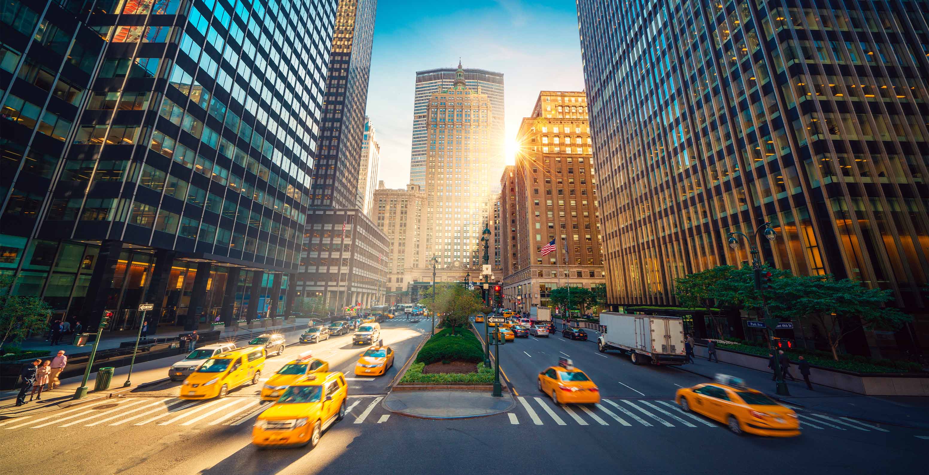 Panoramic view of Fifth Avenue in Manhattan, New York, with tall skyscrapers and yellow taxis