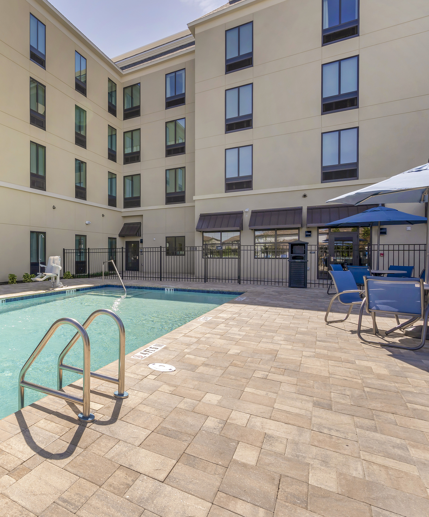 Pestana Orlando hotel near Disney theme parks features a pool with loungers and umbrellas