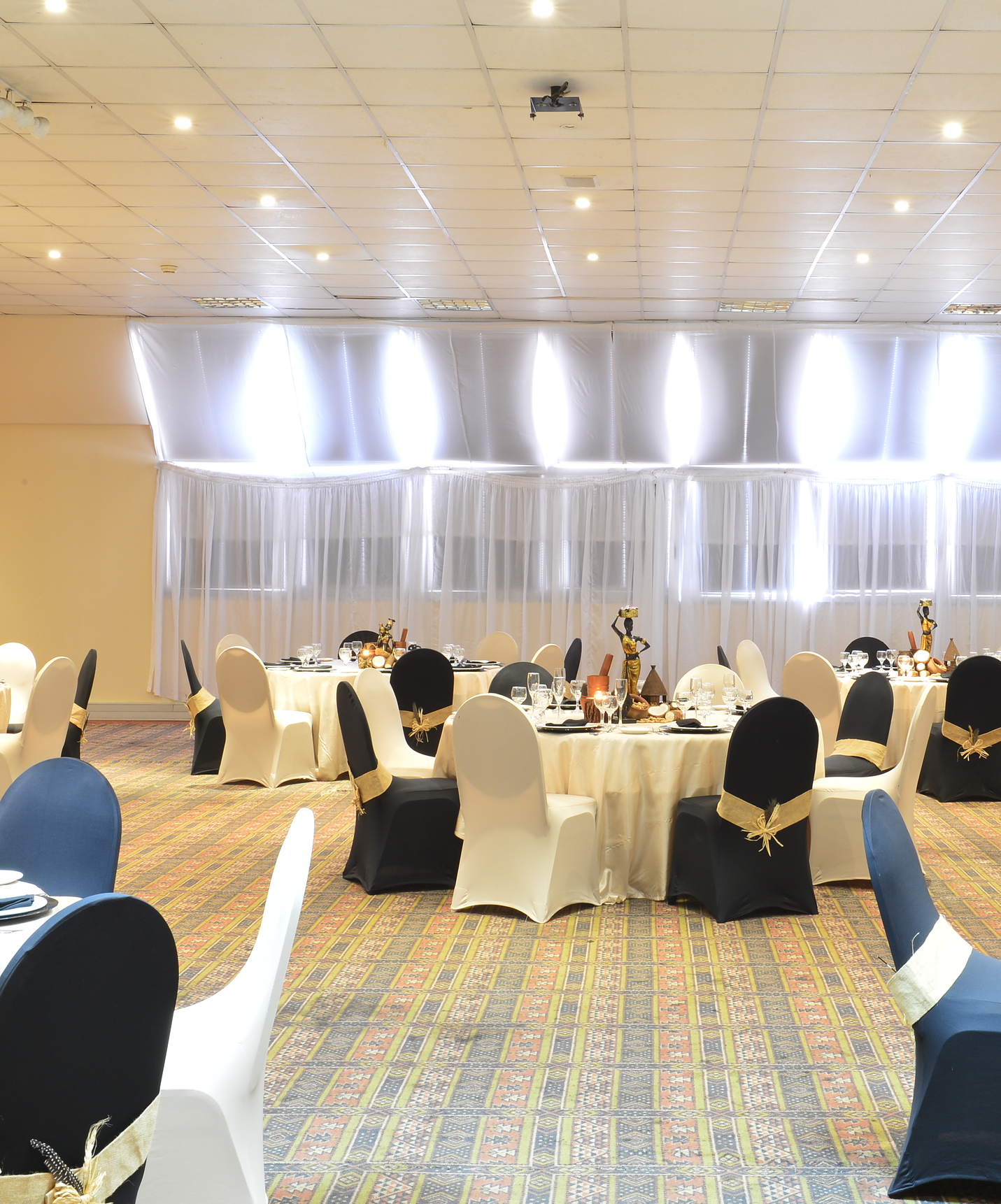 Sala para eventos en hotel en el centro de Maputo, espacio amplio con varias mesas, sillas y columnas para un grupo