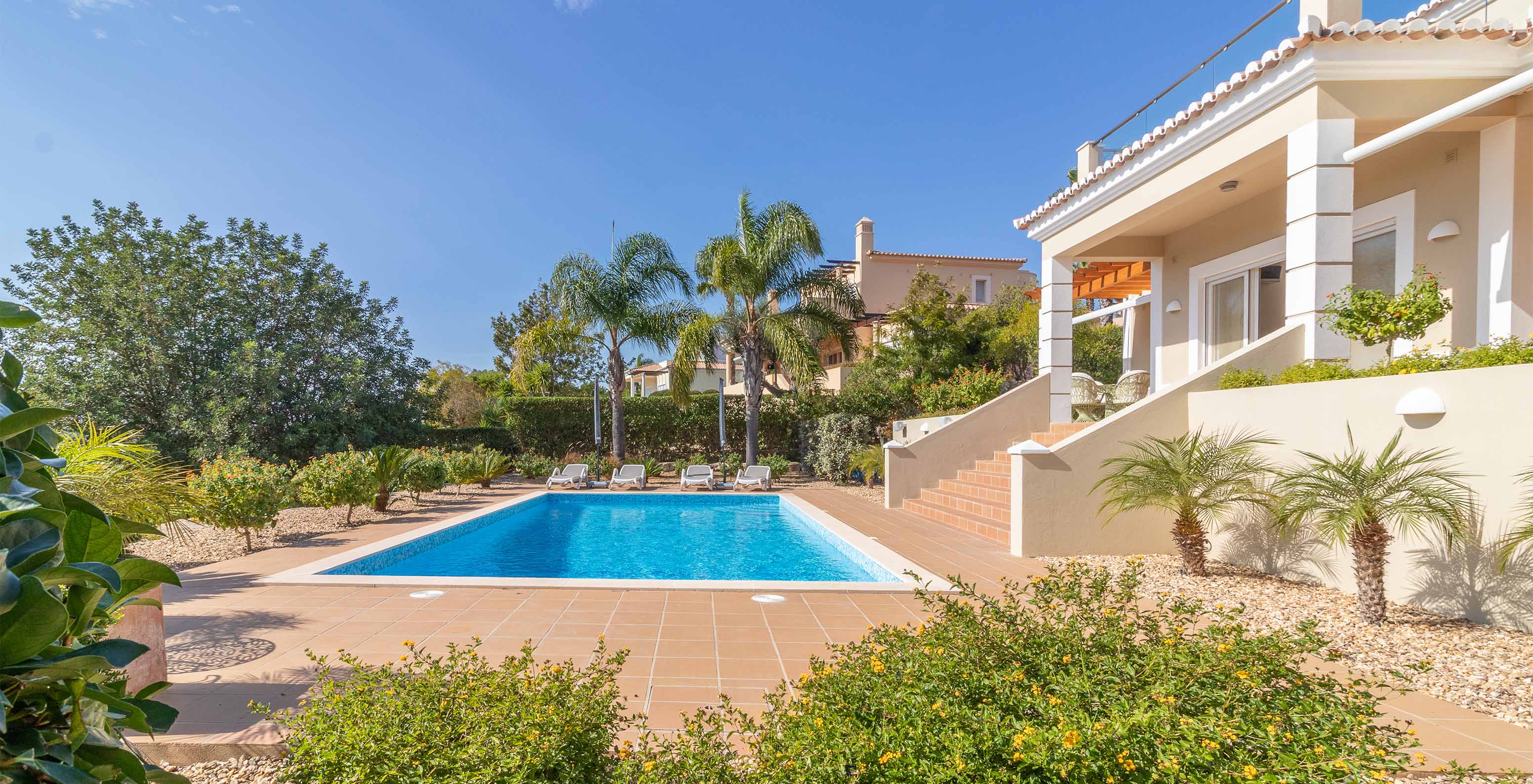 Piscina privada con tumbonas en una villa del Pestana Carvoeiro, hotel en Carvoeiro cerca de Campos de Golf