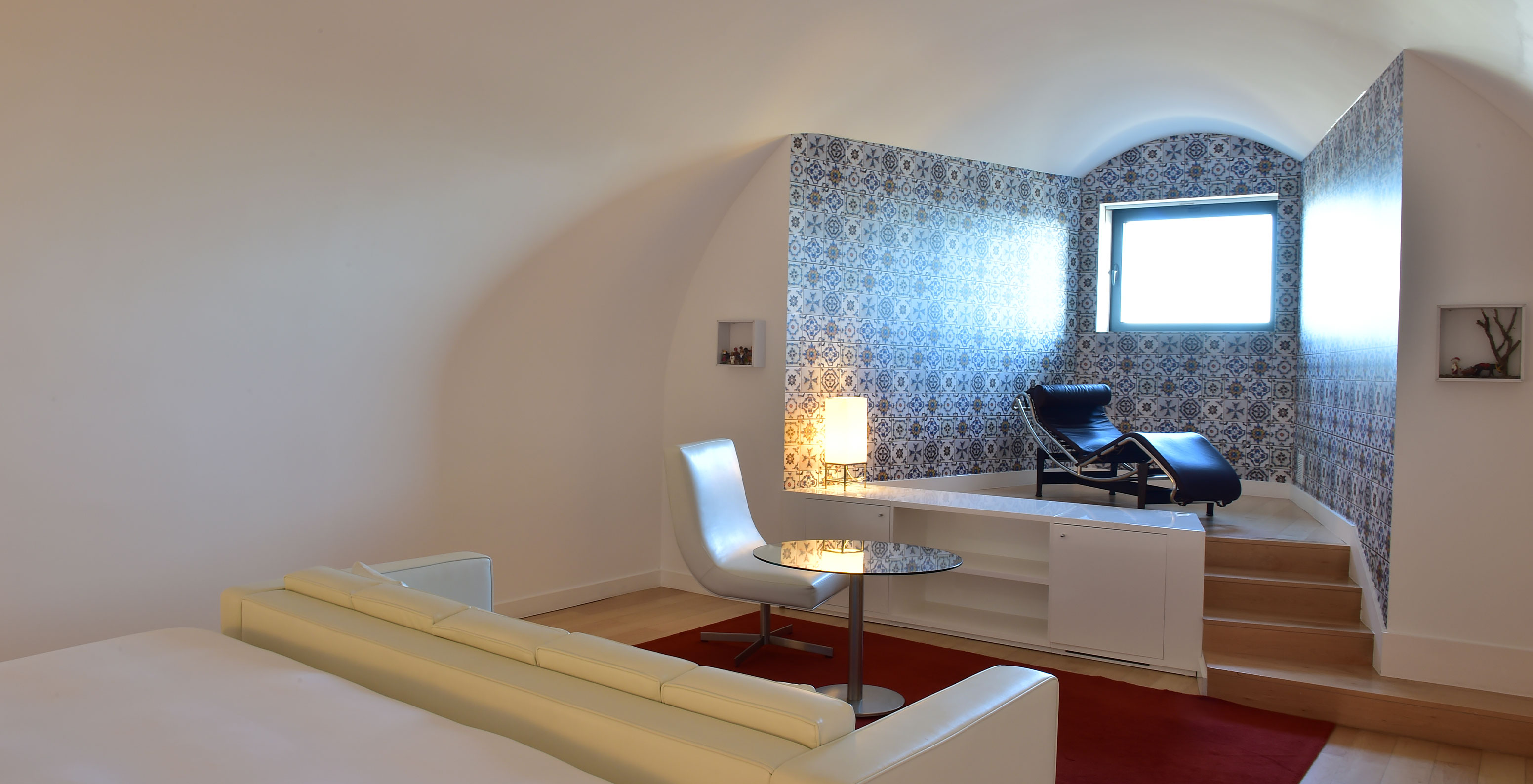 La Junior Suite Art District del Pestana Cidadela Cascais tiene una mesa auxiliar con una silla y una chaise-longue