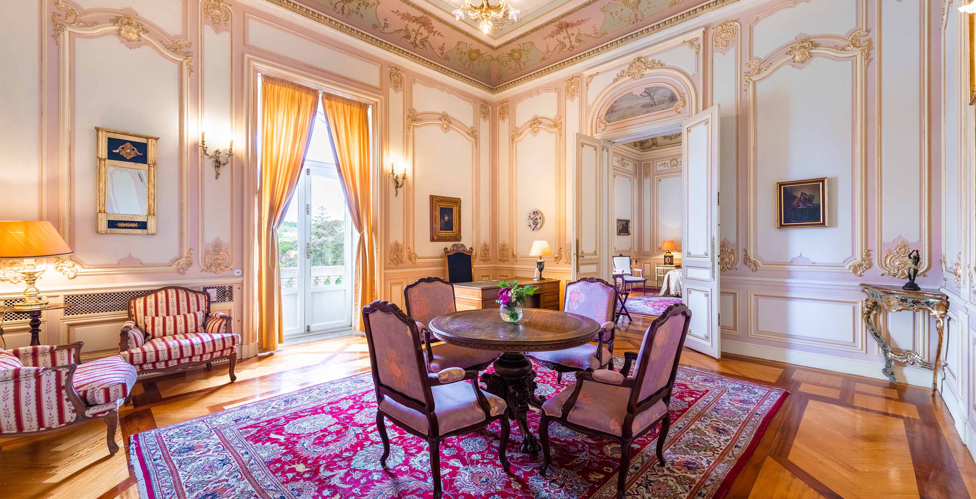 La Suite D. Carlos del Pestana Palace Lisboa tiene un salón grande y lujoso con una ventana y mesa para comidas