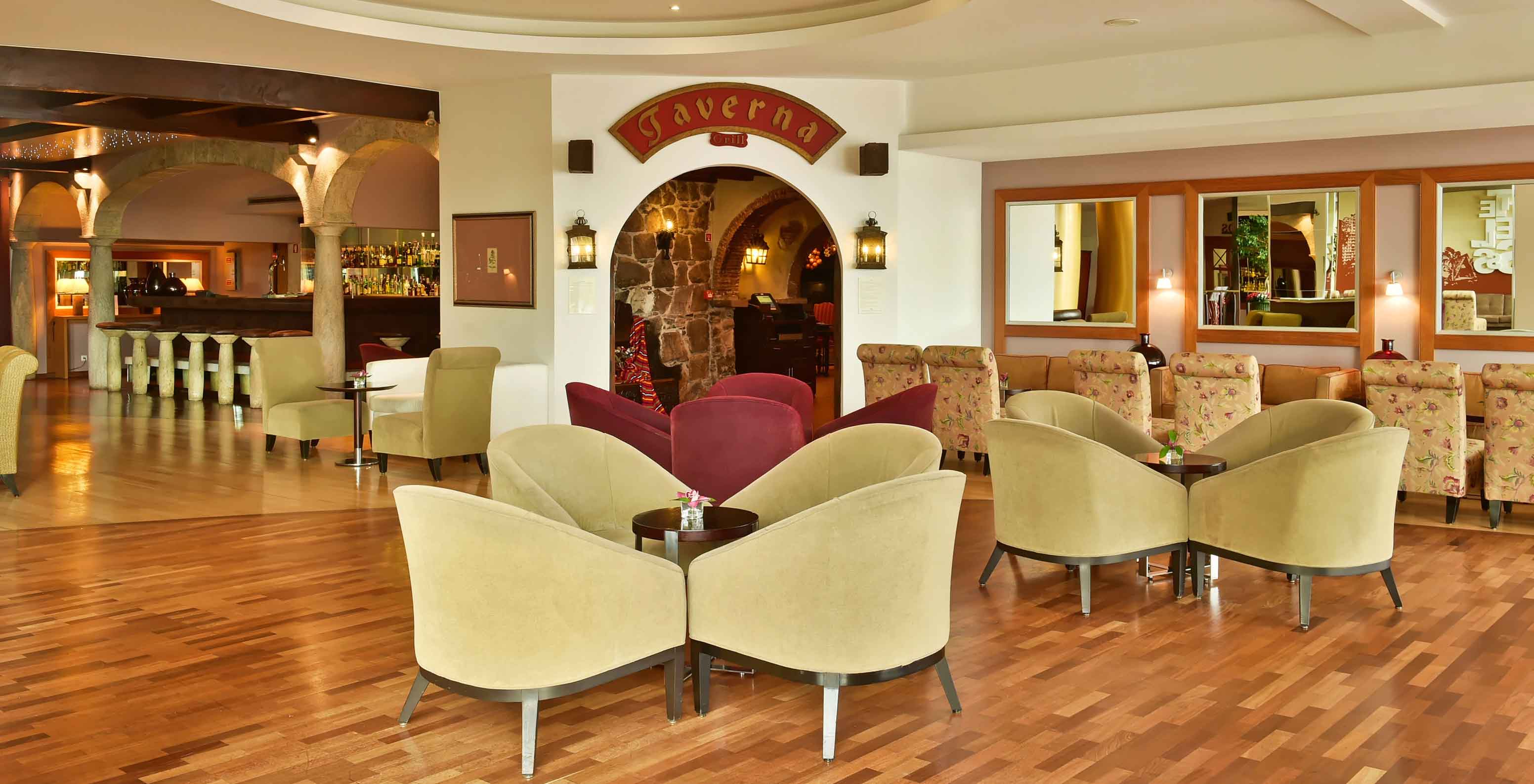 El bar Taverna, en el Hotel de 5 estrellas de Madeira, ofrece bebidas, varios taburetes y sofás