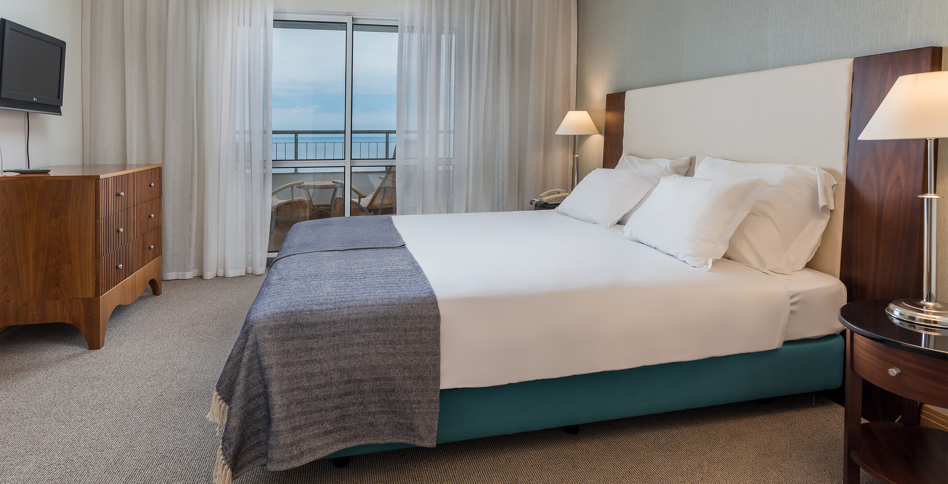 El cuarto Clásico Vista Mar del Pestana Grand tiene una cama de matrimonio con televisor y vista al mar