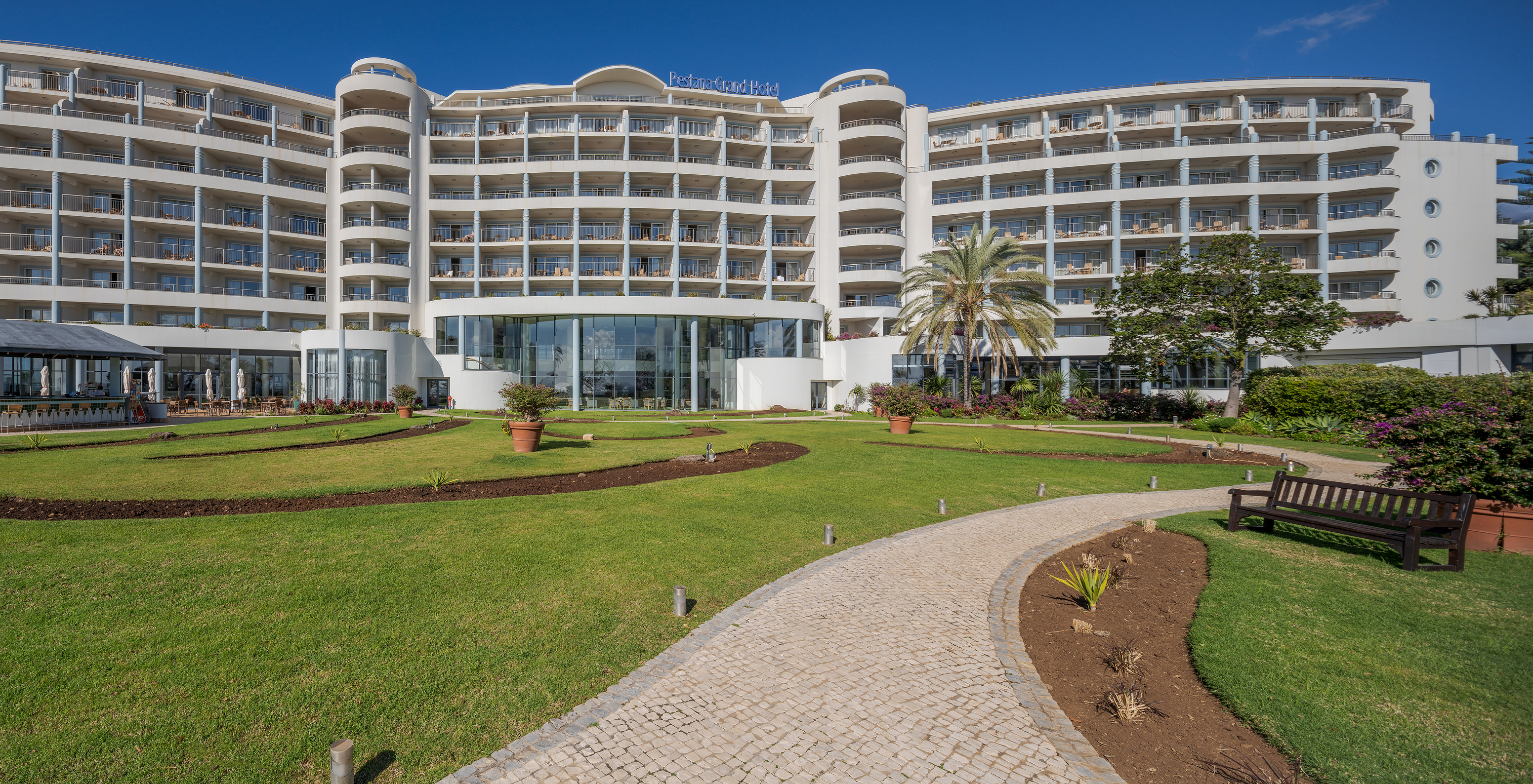 Vista de la fachada del Pestana Grand, con jardines de césped frente al hotel