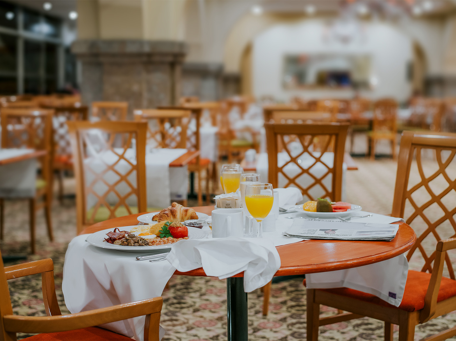 El restaurante Arcos, en el Hotel en el Centro de Funchal, Madeira, tiene una alfombra con flores y varias mesas puestas