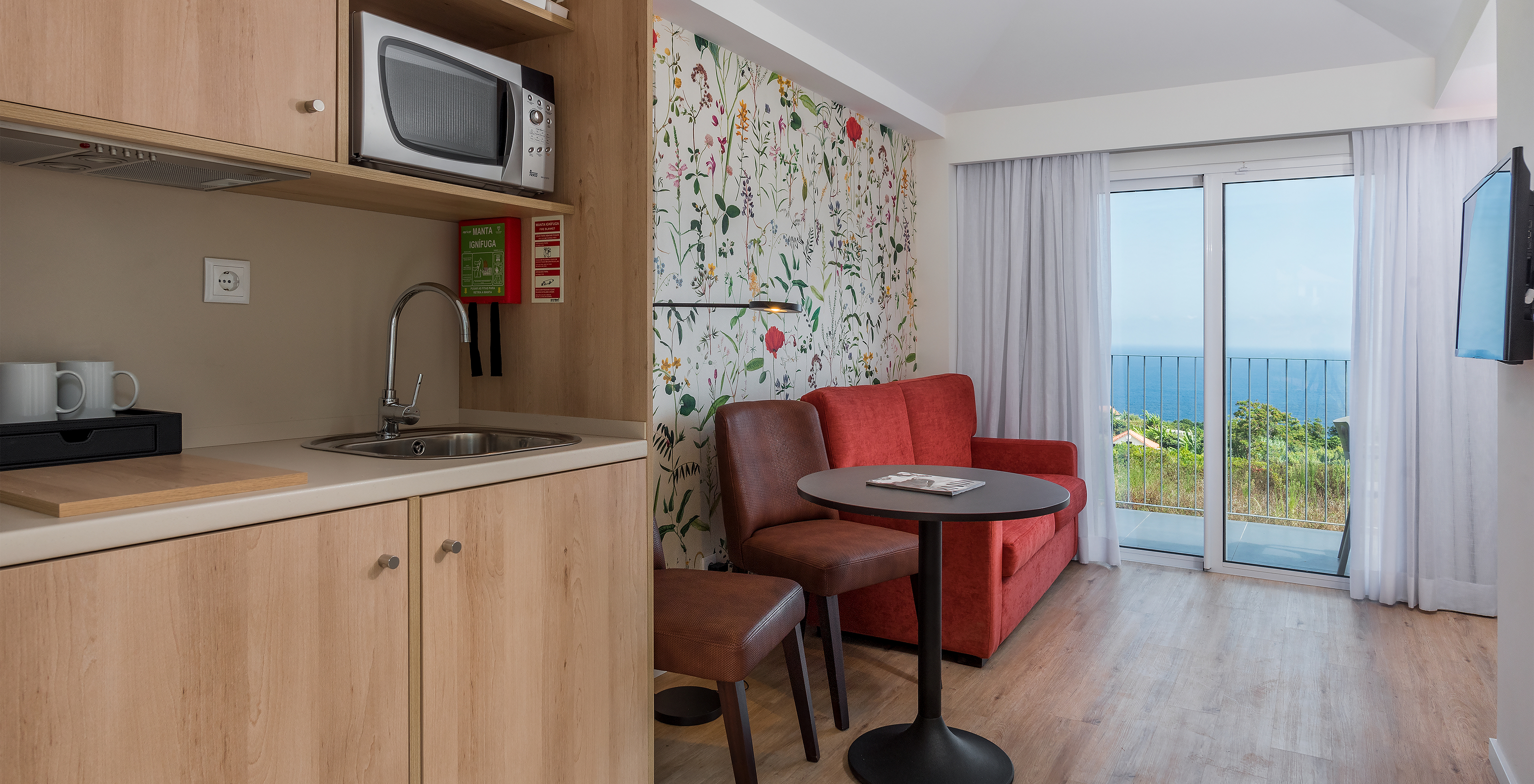 El Estudio - Vista mar del Pestana Quinta do Arco tiene kitchenette, sofá, televisión, mesa y sillas, y balcón con vista mar