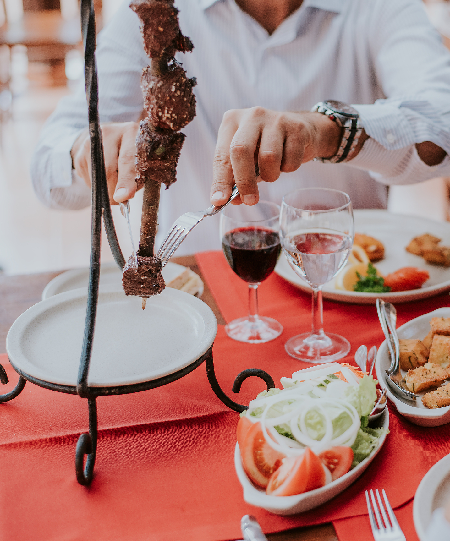 Personas comiendo espetadas típicas de Madeira, en el Pestana Village, un hotel romántico en Funchal