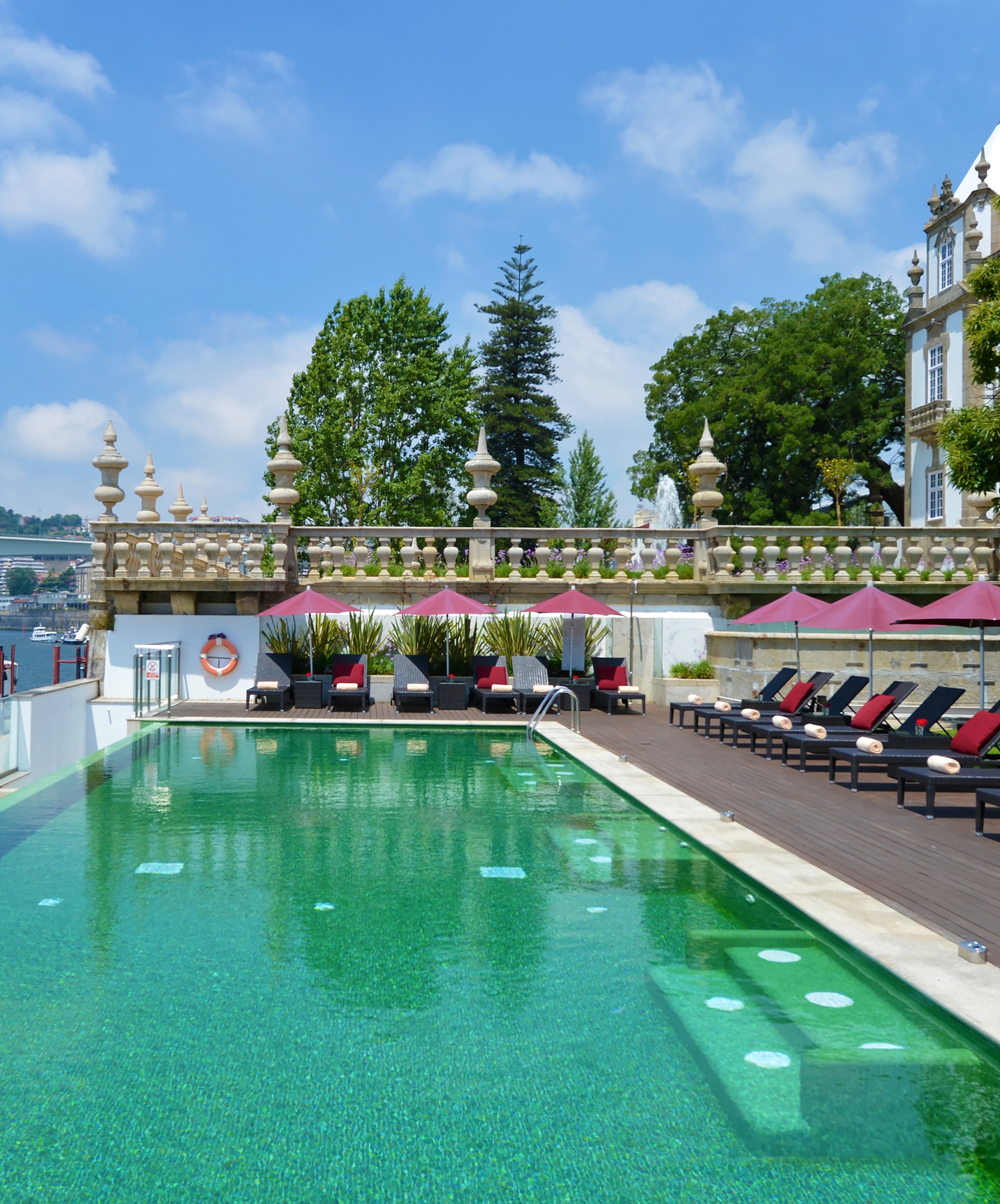 Piscina exterior infinita y tumbonas con toldos en el Pestana Palácio do Freixo, hotel en el río Douro con spa y piscina