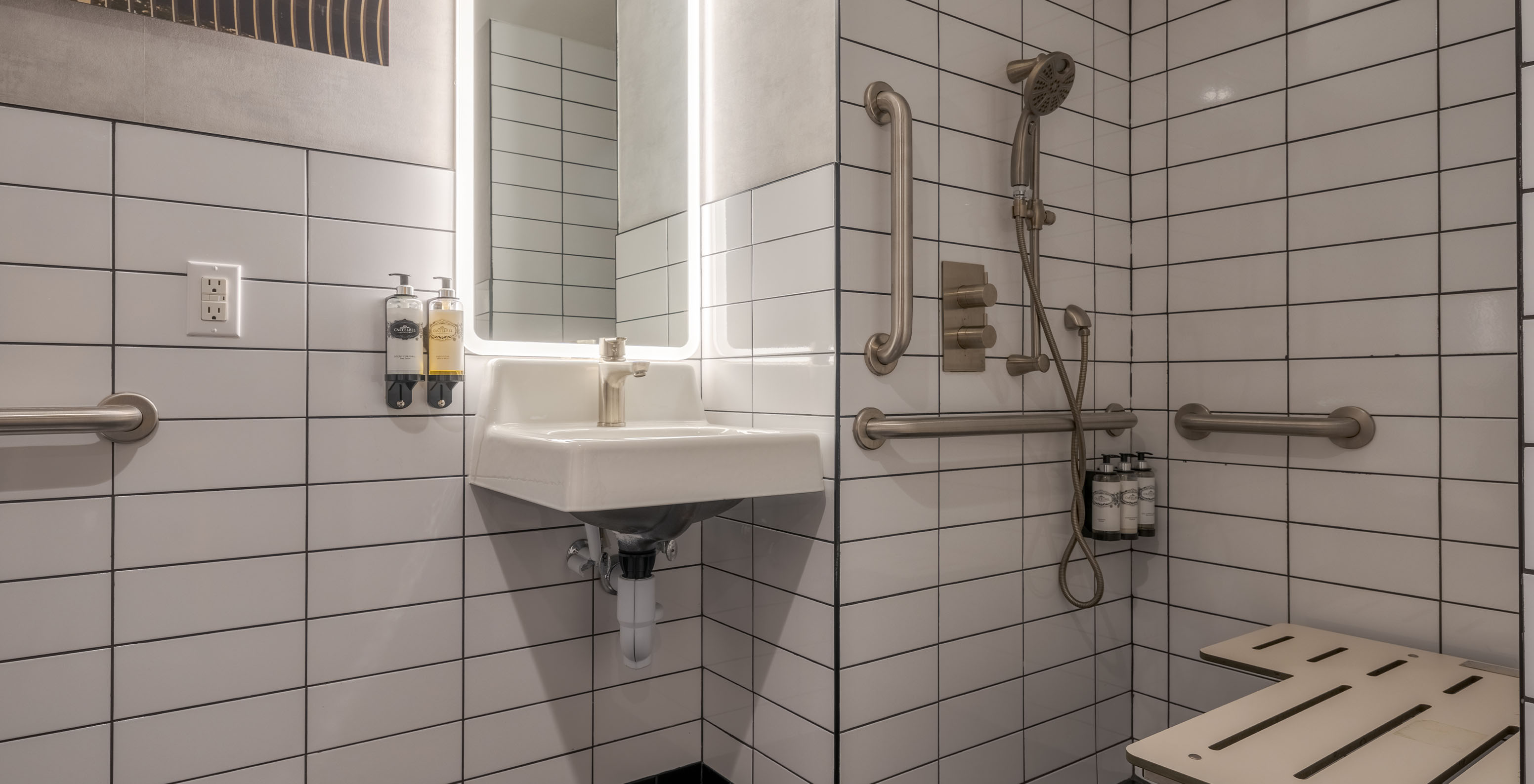 El Deluxe King ADA del Pestana CR7 Times Square tiene un baño adaptado con ducha, lavabo y espejo