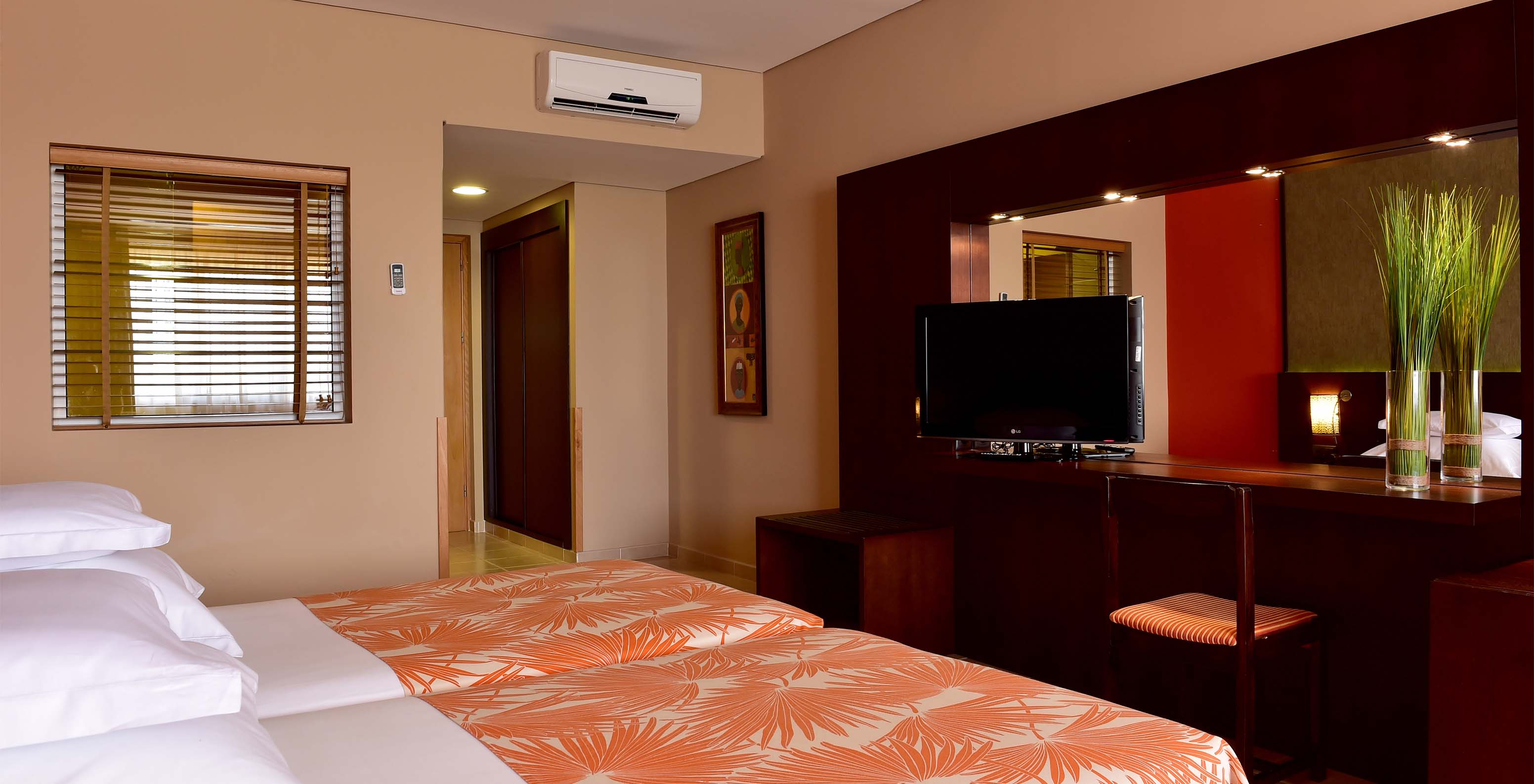 The Classic Sea View room at Pestana Tropico features two single beds, television, bedside table, and mirror