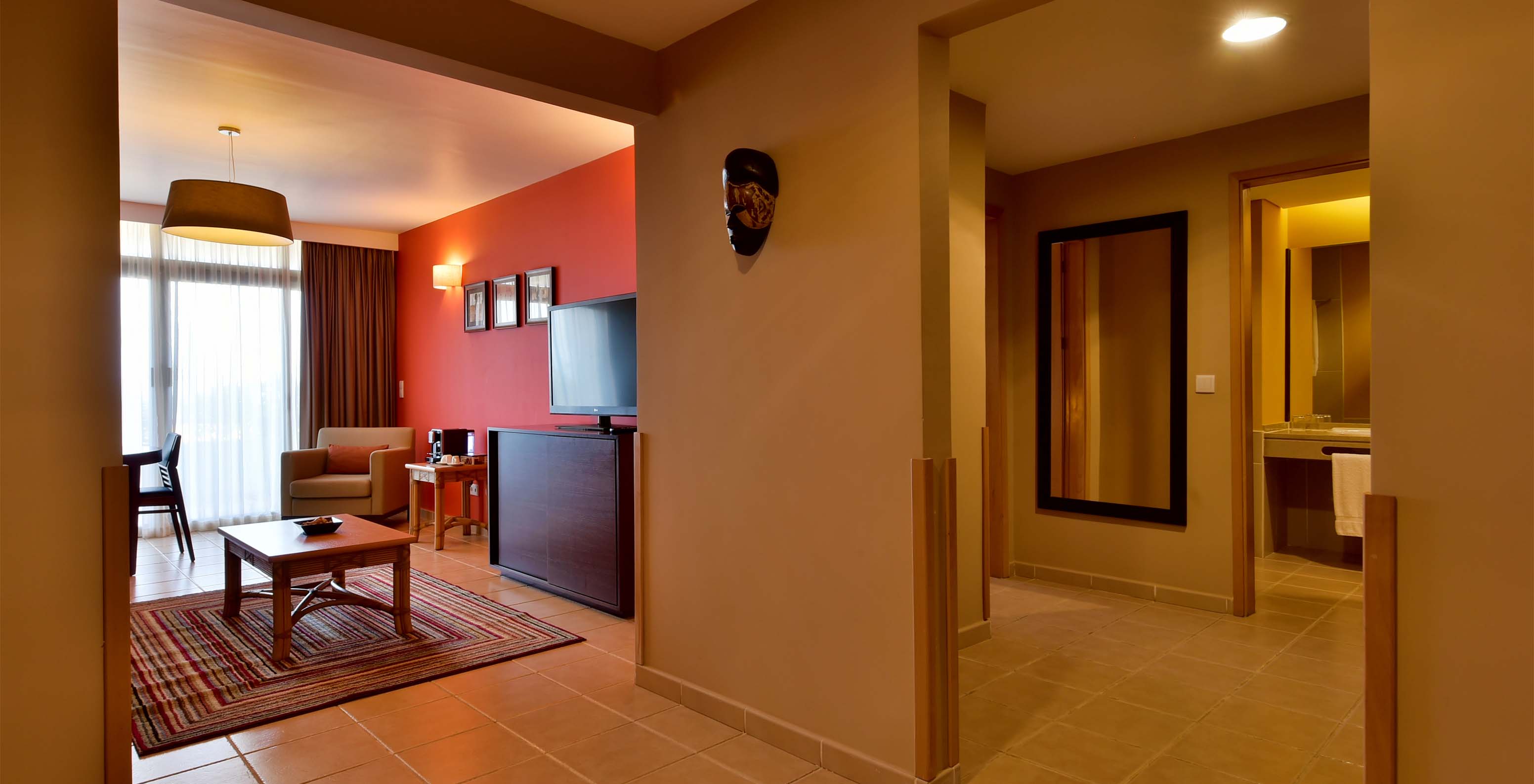 The Suite at Pestana Tropico features a living room with television and a bathroom