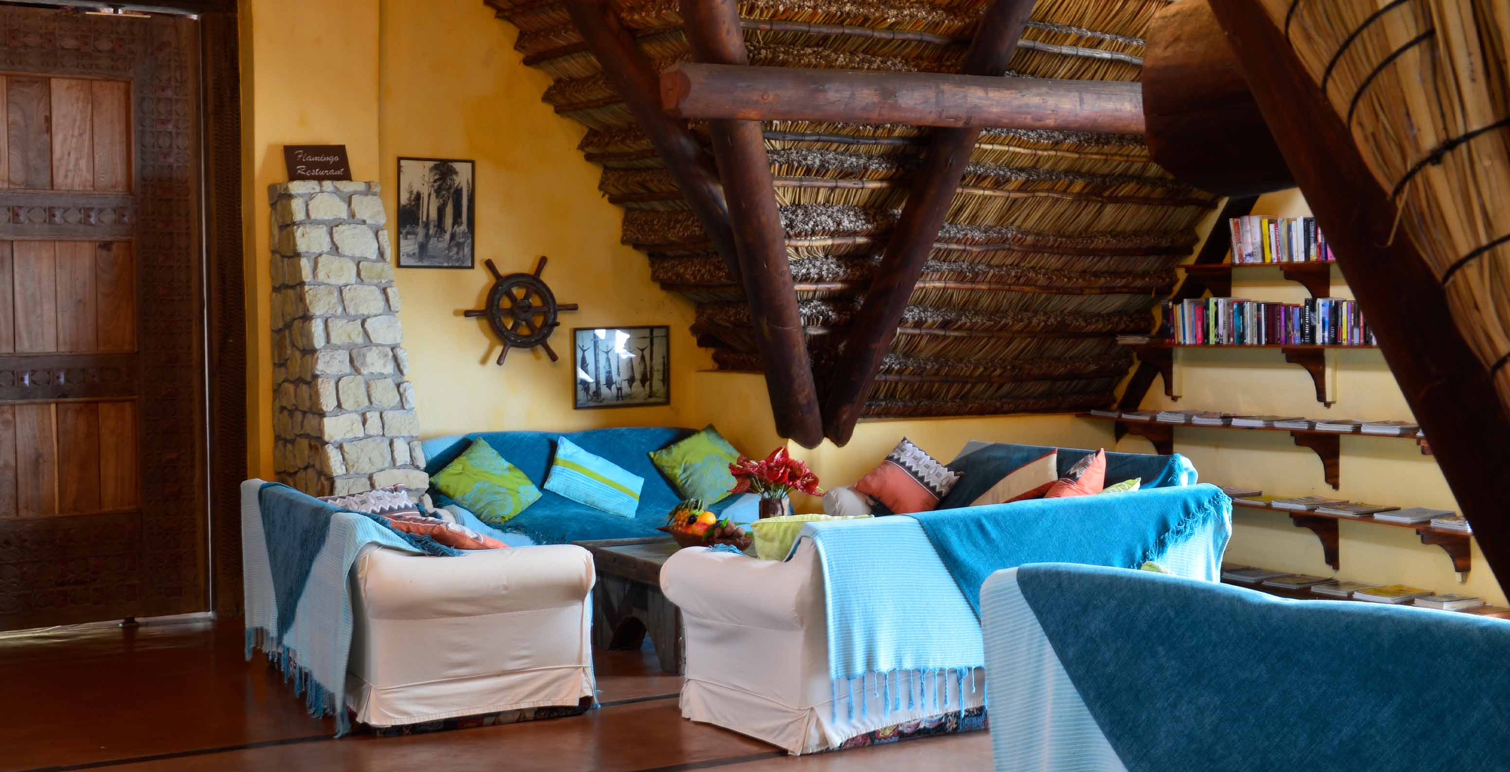 El Bungalow Suite T2 del Pestana Bazaruto Lodge tiene sala amplia con sofás cubiertos con mantas azules y cojines coloridos