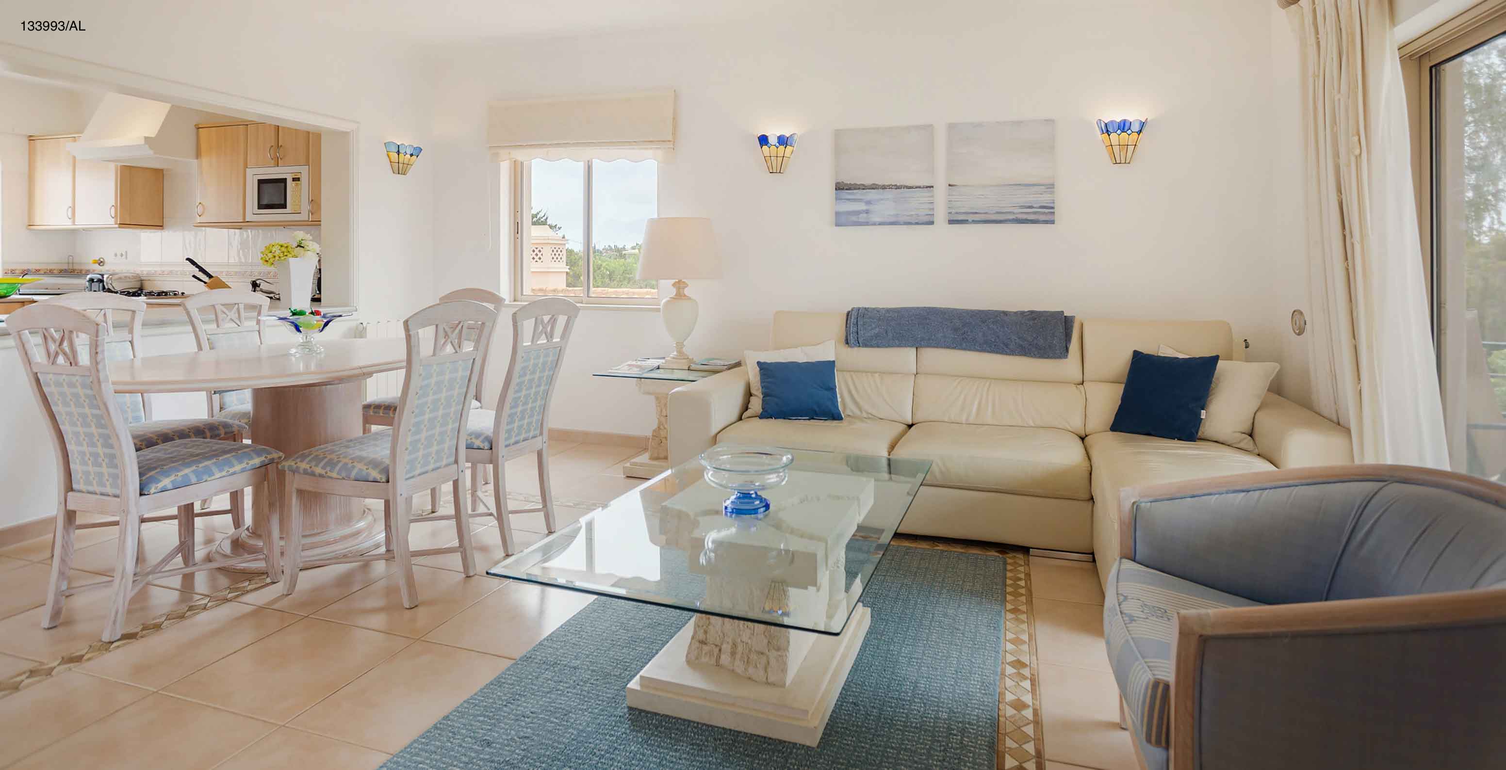 El apartamento Pestana Carvoeiro Golf T2 Superior tiene una sala de estar con sofá blanco, mesa de comedor y seis sillas