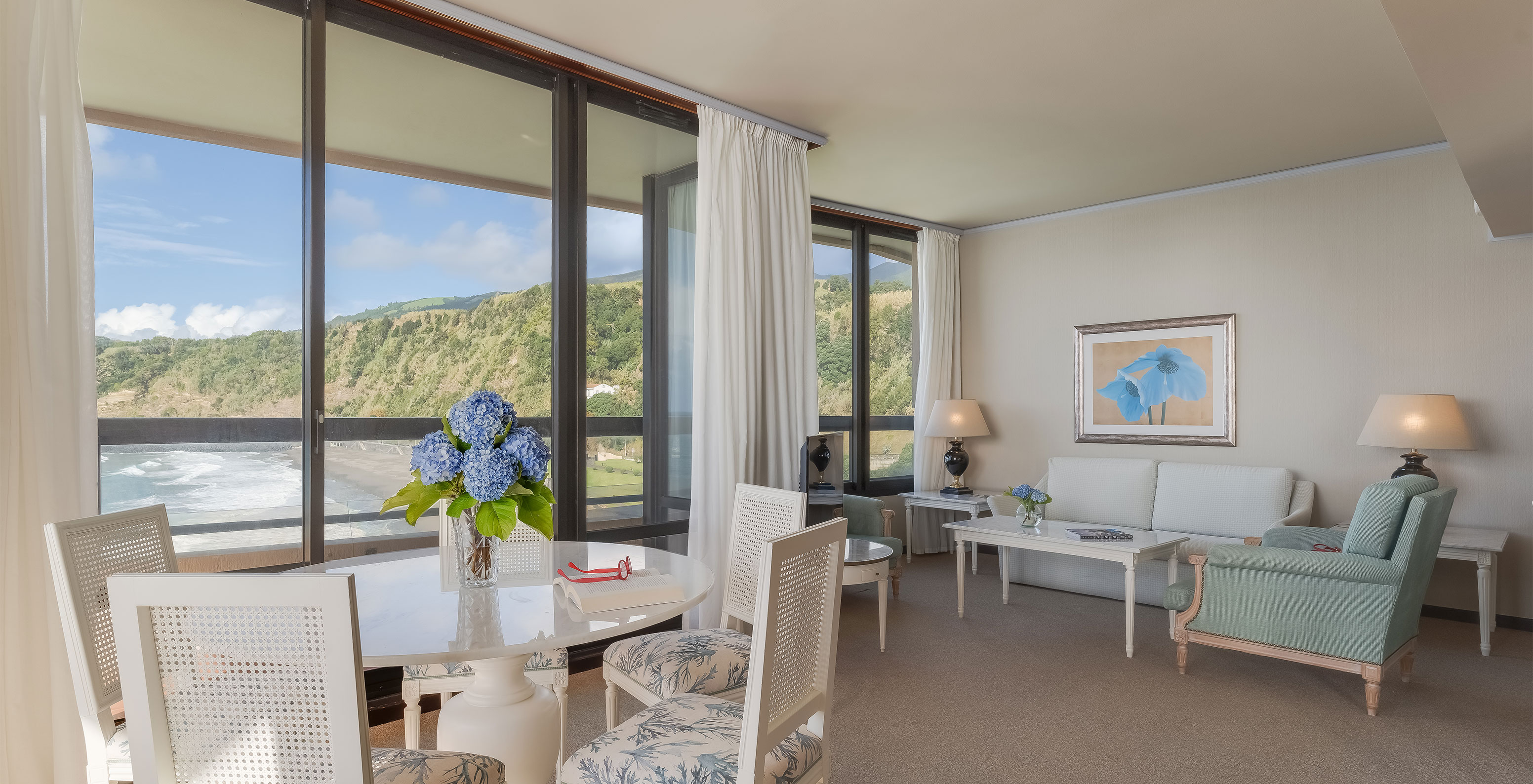 La Suite del Pestana Bahia Praia tiene sala con vista a la playa junto al hotel y a la naturaleza verde