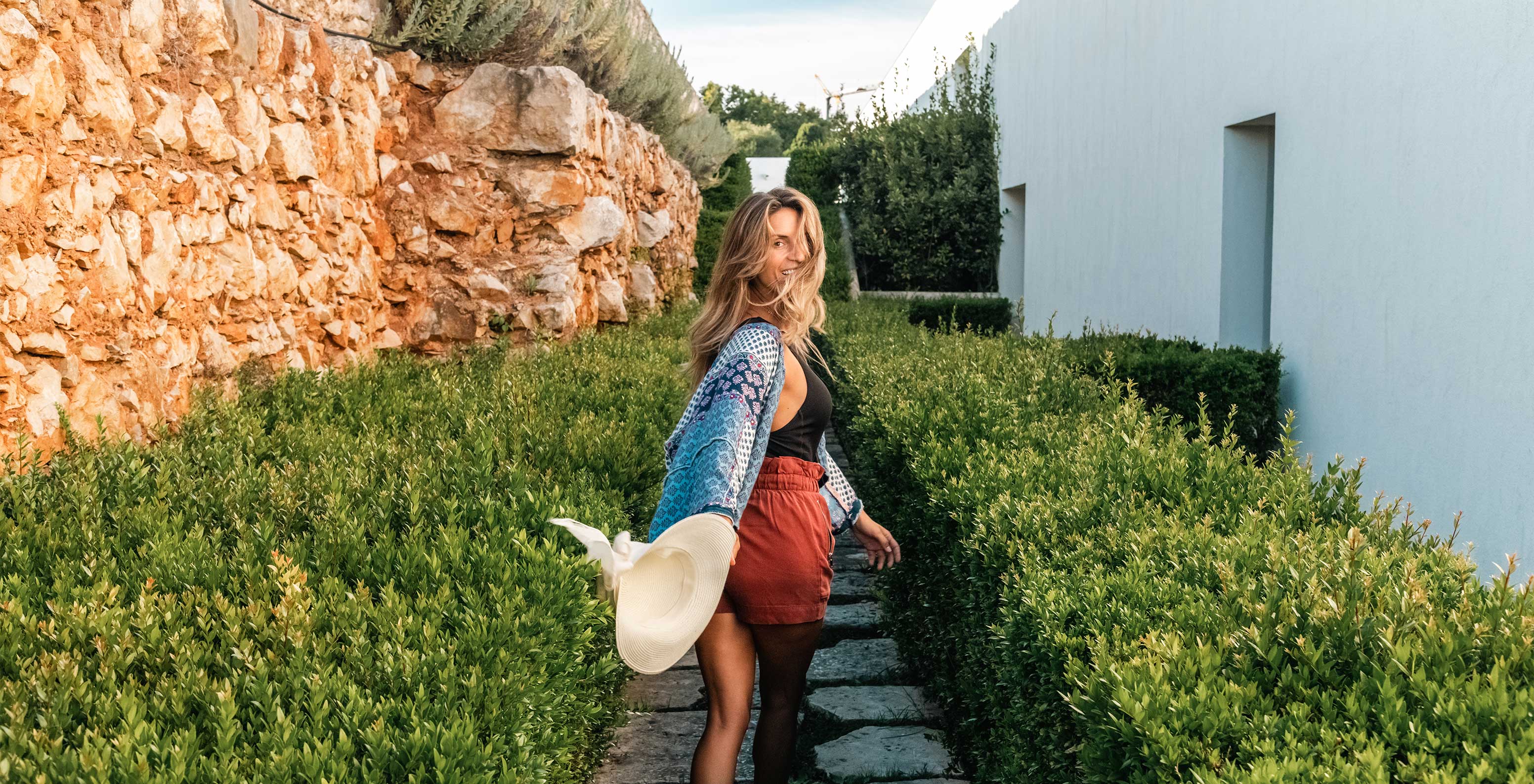 Chica sonriente paseando por los jardines del Pestana Cidadela Cascais un hotel 5 estrellas en Cascais con spa