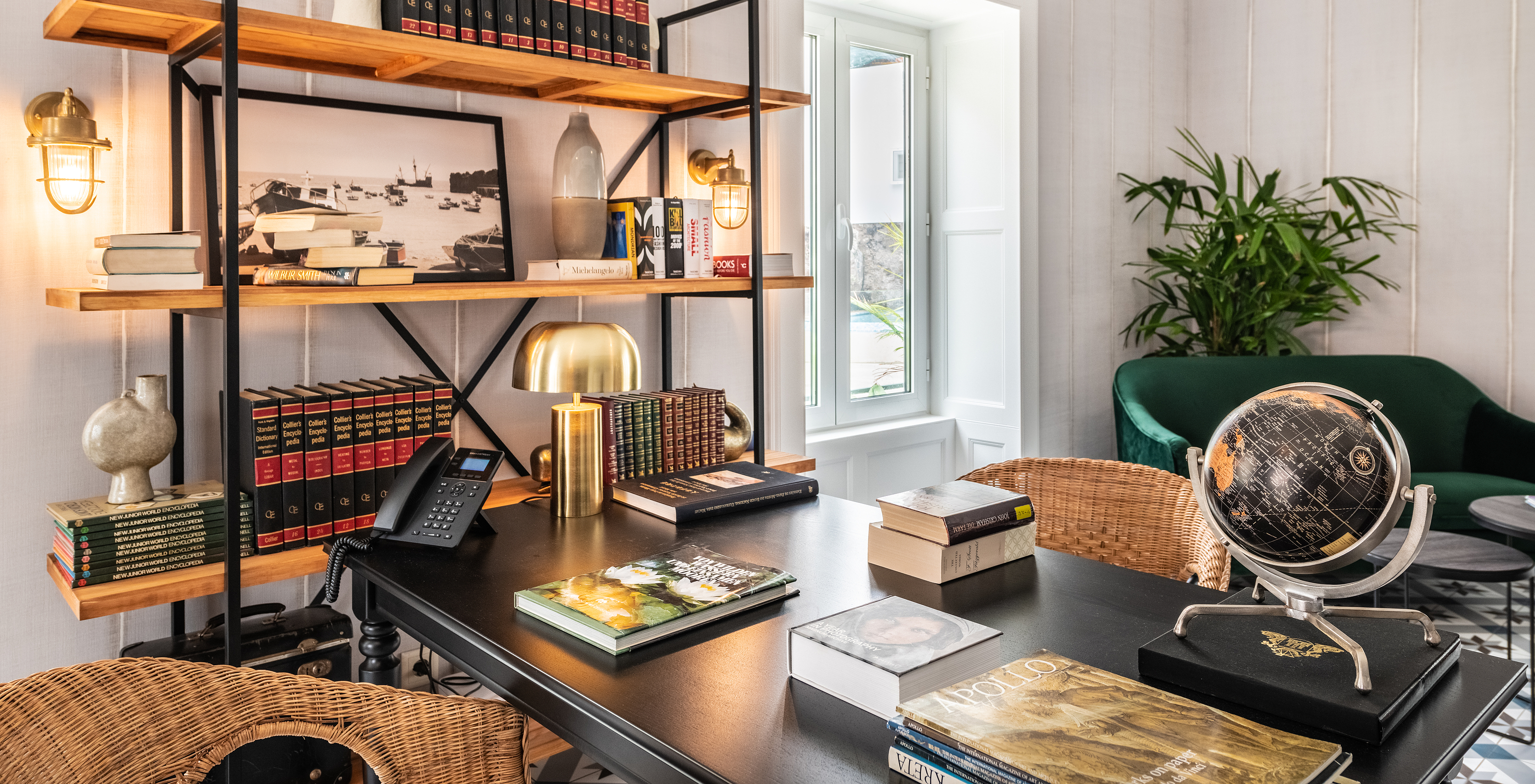 Biblioteca del hotel boutique en el centro histórico de Câmara de Lobos con estanterías con libros y objetos decorativos