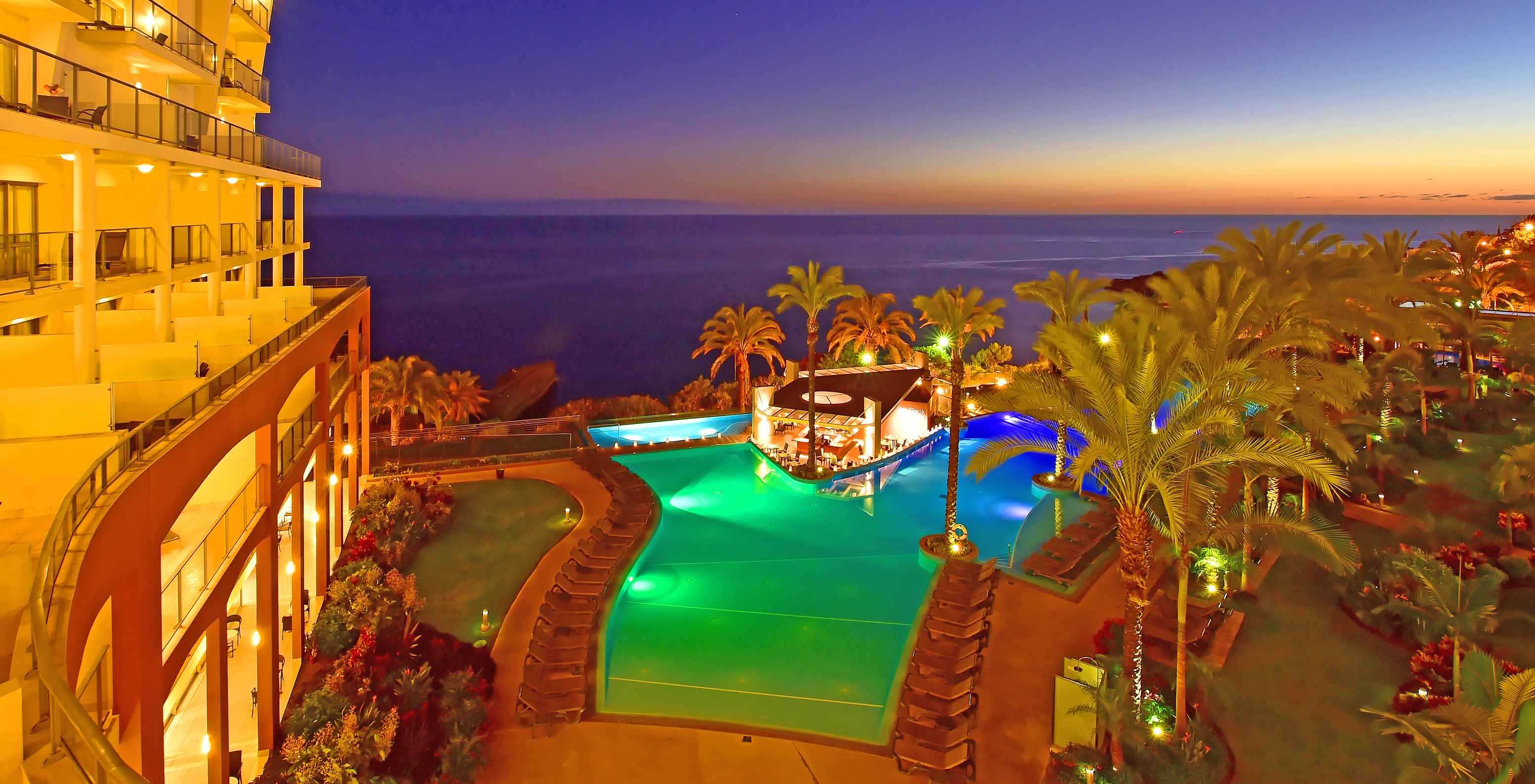 El Pestana Promenade un Hotel en Madeira cerca de la Playa y del Lido tiene una vista nocturna al mar y a la piscina