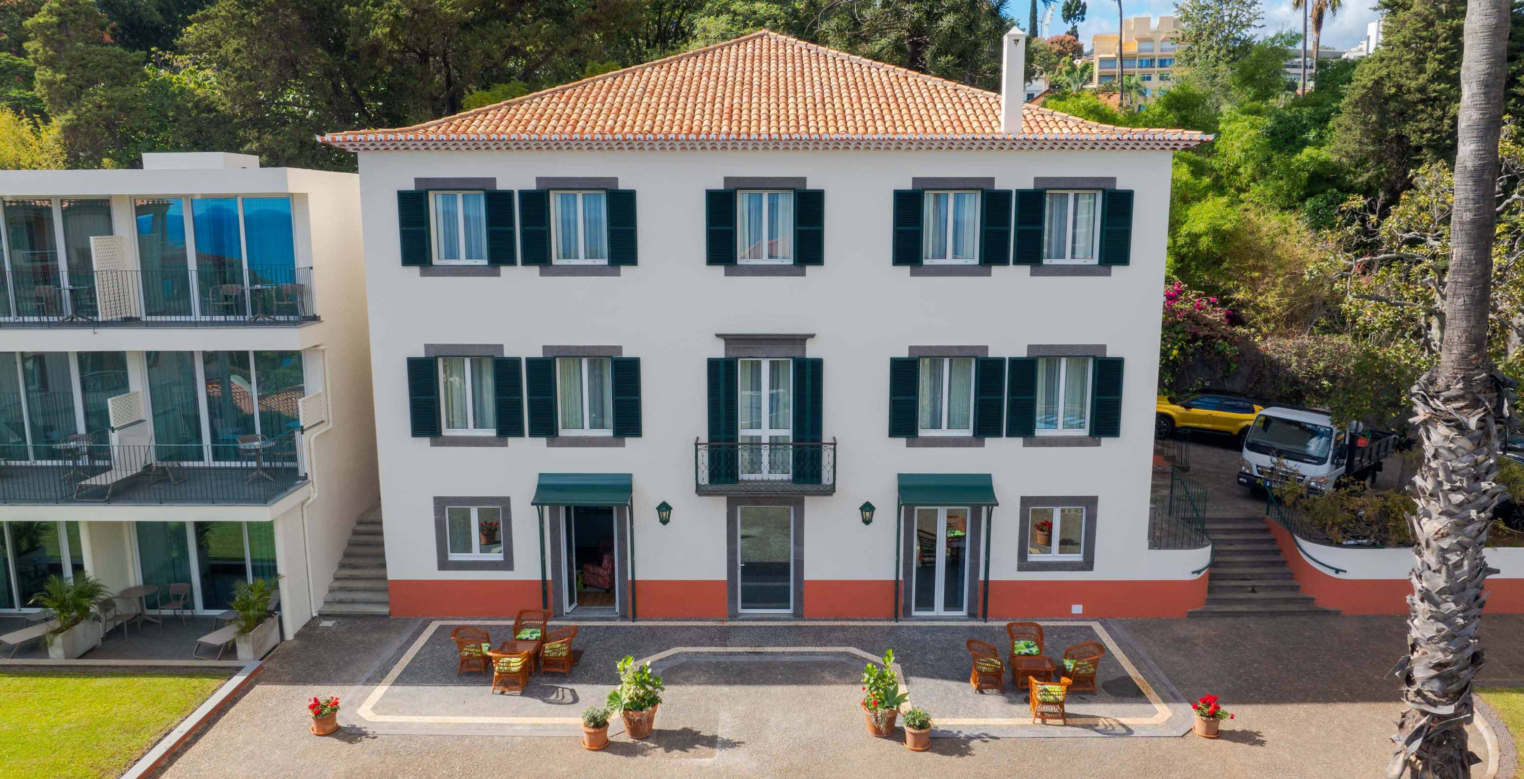 Fachada do edifício do Pestana Quinta Perestrello, um Hotel de Charme na Madeira, rodeado por árvores