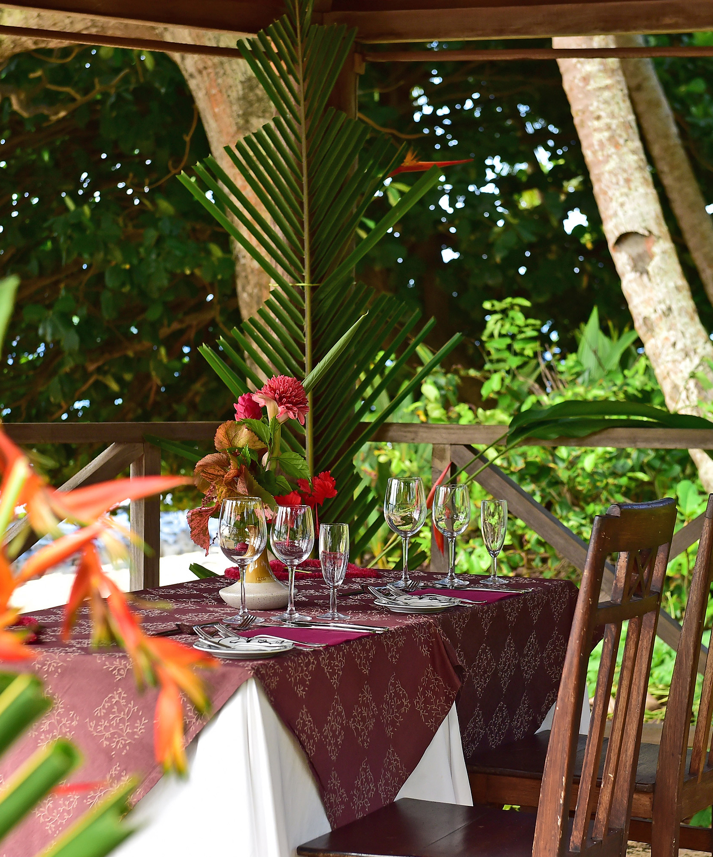 Restaurante del hotel para vacaciones, con piscina y spa, frente a la playa, rodeado de flores y vegetación verde