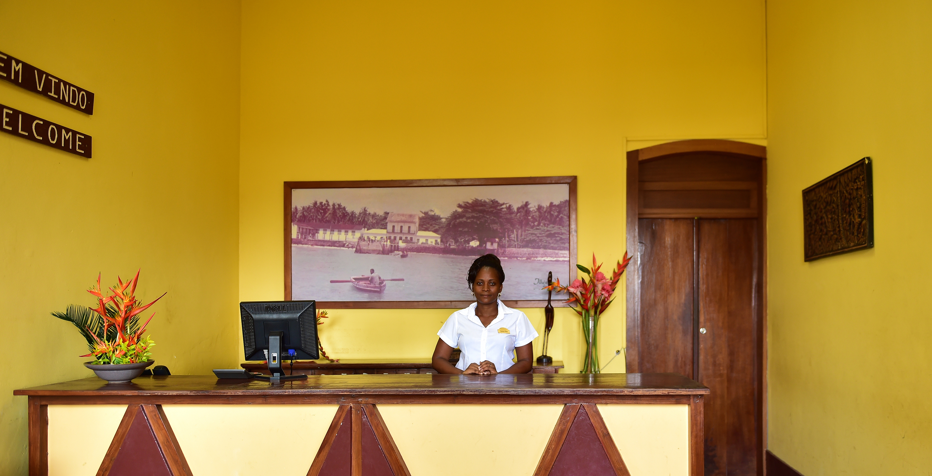 Recepción del hotel para vacaciones con piscina y spa frente a la playa con personal sonriente listo para atender