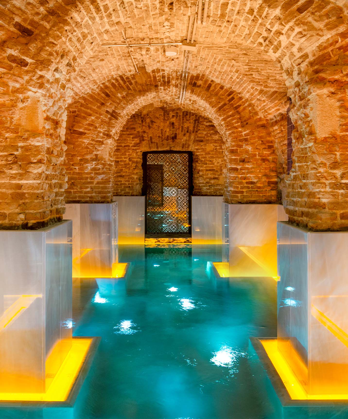 Piscina interior del hotel con piscina en la Plaza Mayor, en Madrid, con techos abovedados y paredes de ladrillo rojo