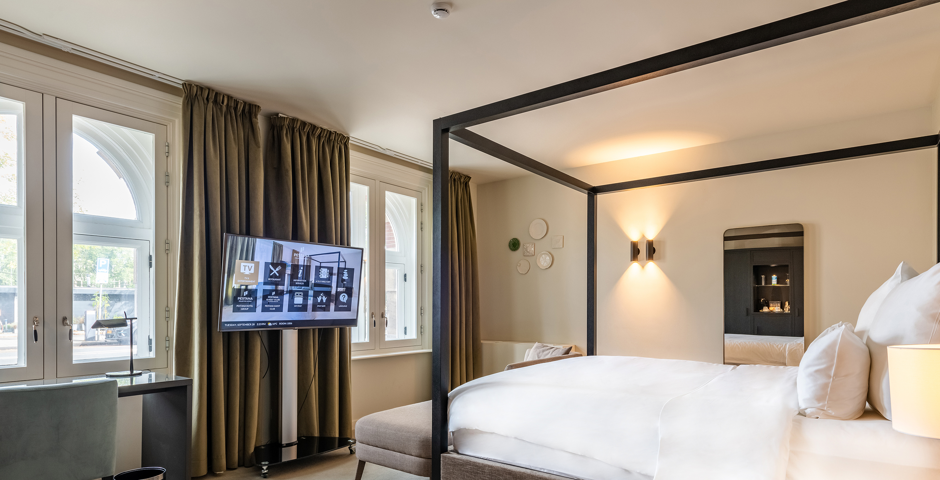 El cuarto Premium Deluxe del Pestana Amsterdam Riverside tiene una televisión frente a la cama y un escritorio con silla