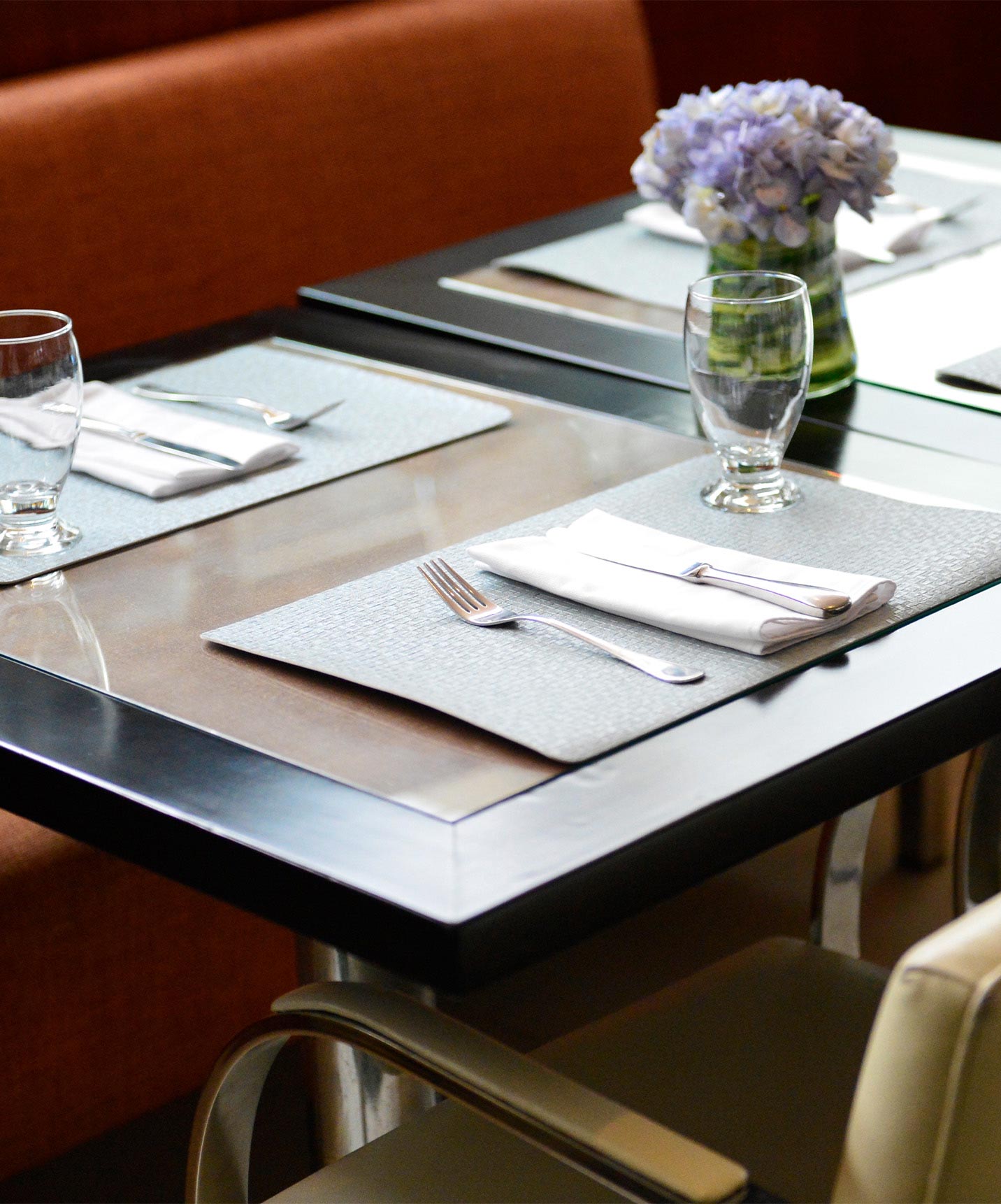 Mesa del restaurante del hotel en Caracas, cerca del área financiera, con cubiertos, servilleta y un vaso de vidrio