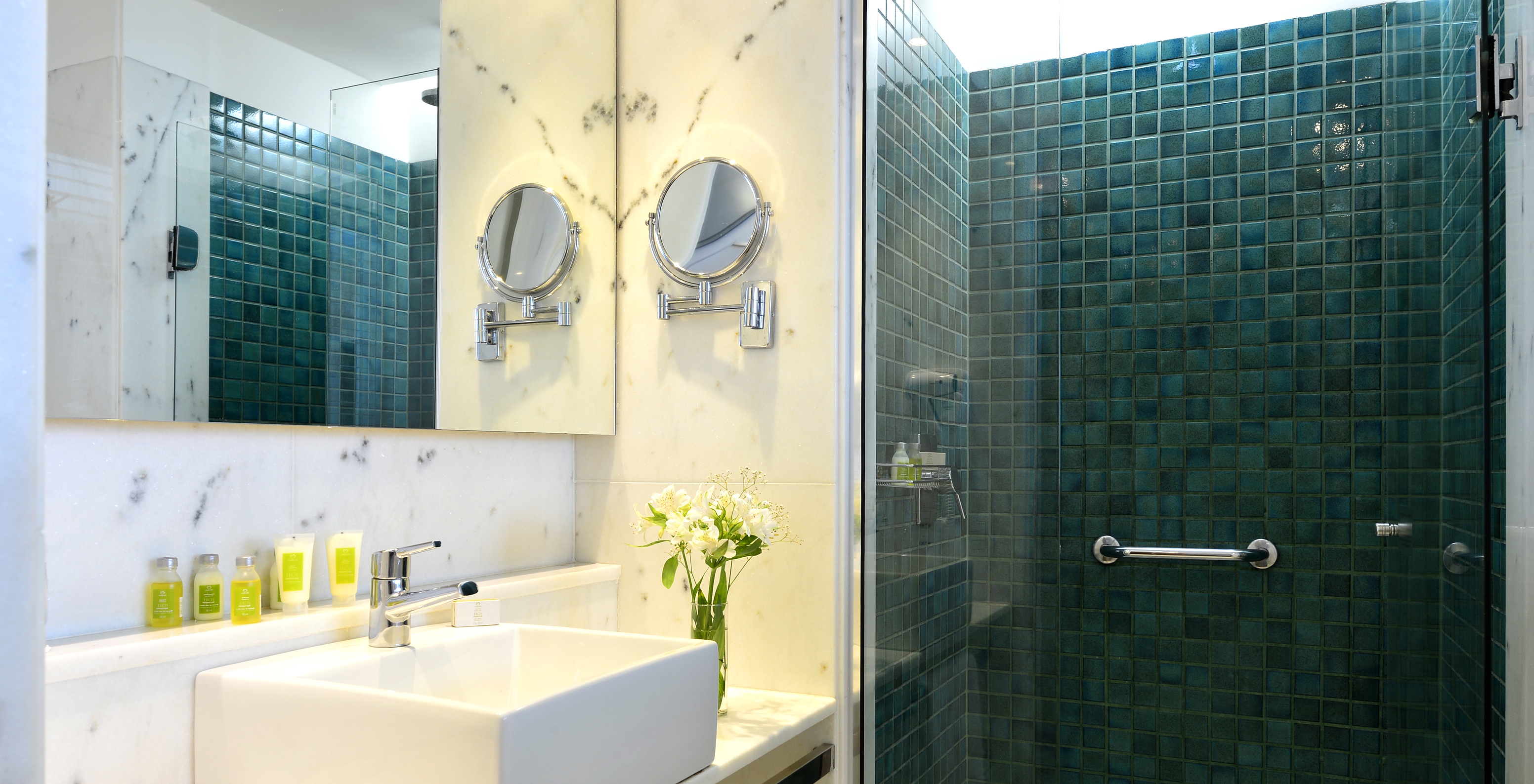 Le Chambre Standard Twin du Pestana Rio Atlântica a une salle de bain avec douche, lavabo avec miroir et amenities