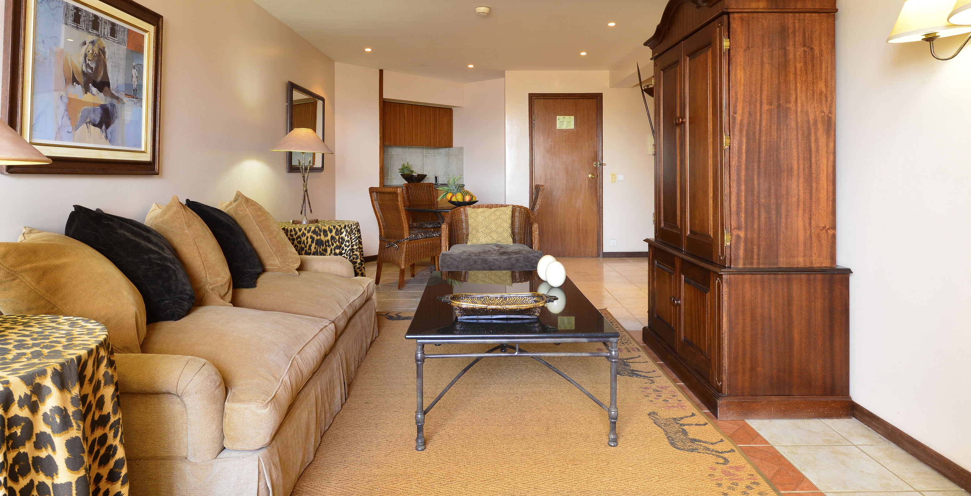 La Suite Luxe du Pestana Rovuma a un salon avec un canapé blanc beige et deux tables avec nappes léopard