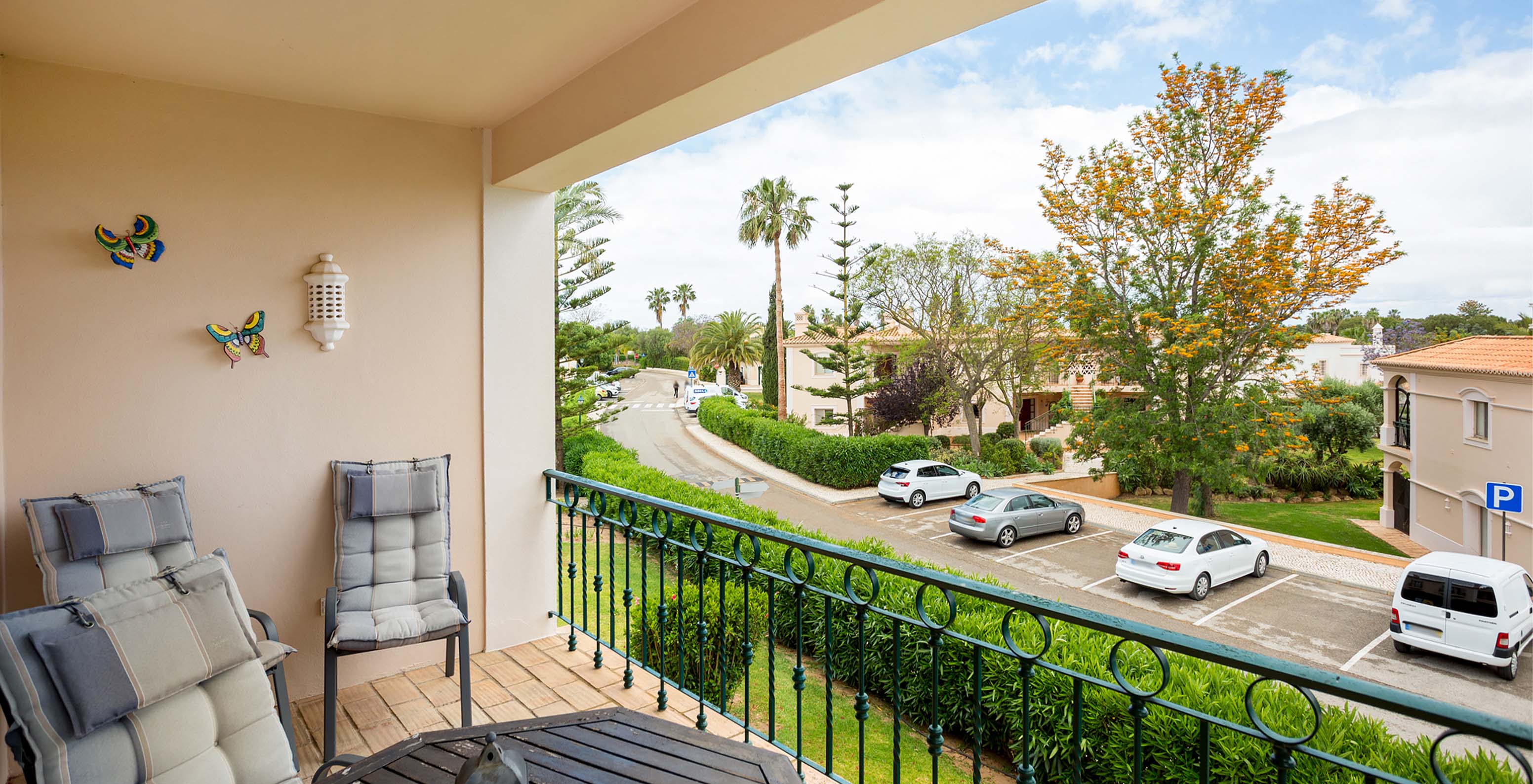 L’Appartement T2 du Pestana Carvoeiro Golf a un balcon avec table et chaises et vue sur l'extérieur de l'hôtel