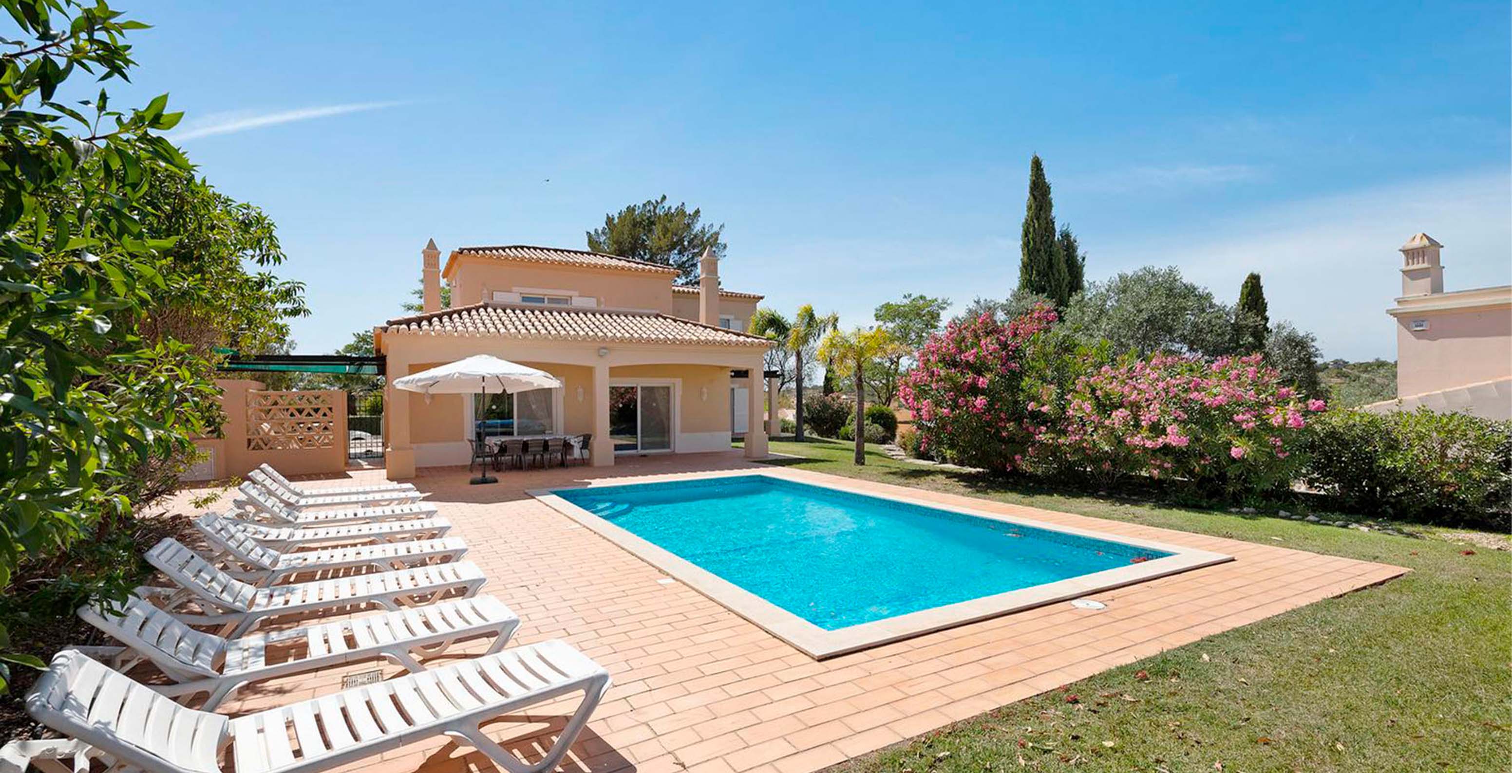 La Villa V4 du Pestana Carvoeiro Golf a un jardin privé avec piscine extérieure, des transats et une table pour les repas