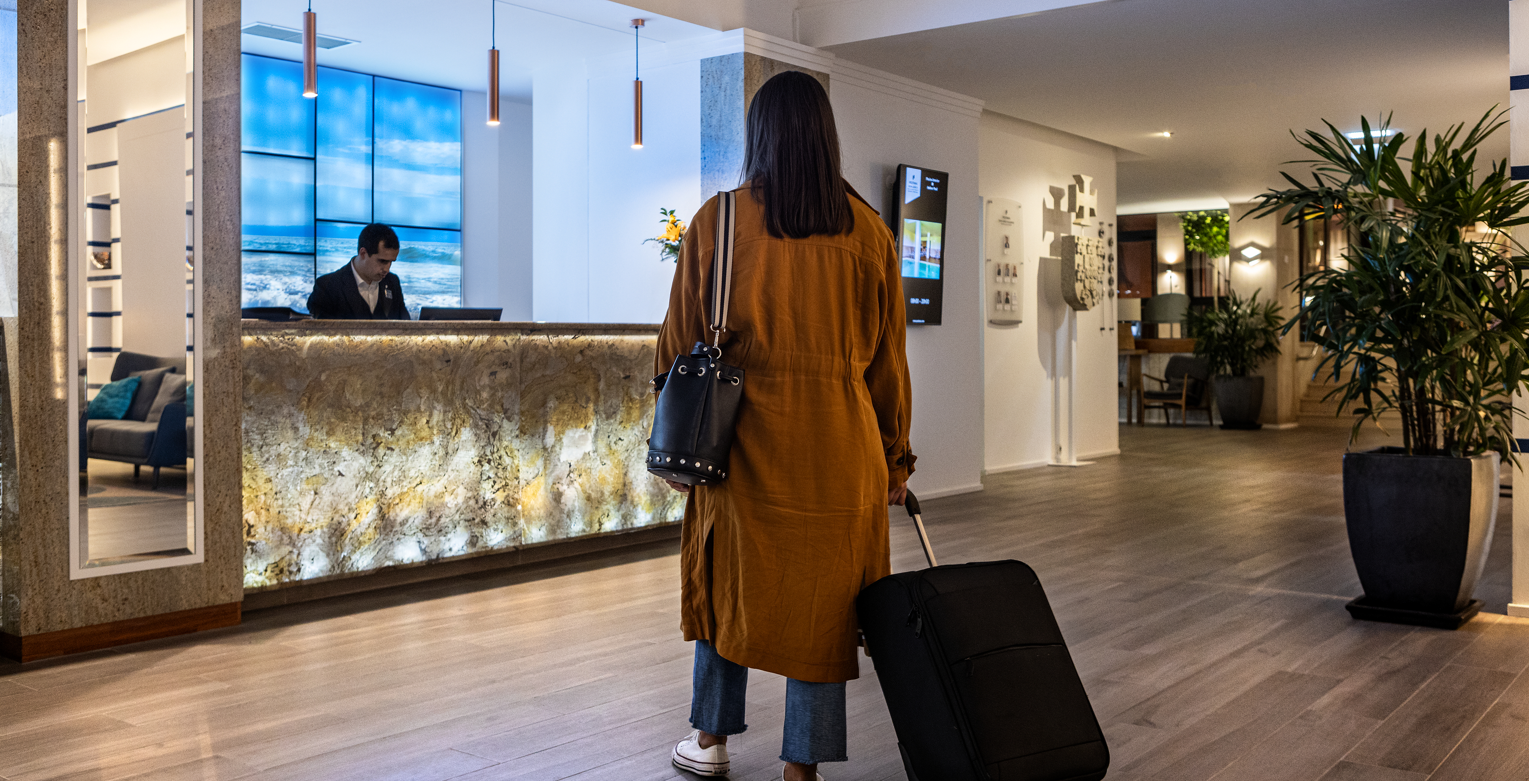 Personne avec une valise, dans le lobby d'entrée de l'hôtel, arrivant à la réception du Pestana Dom João II