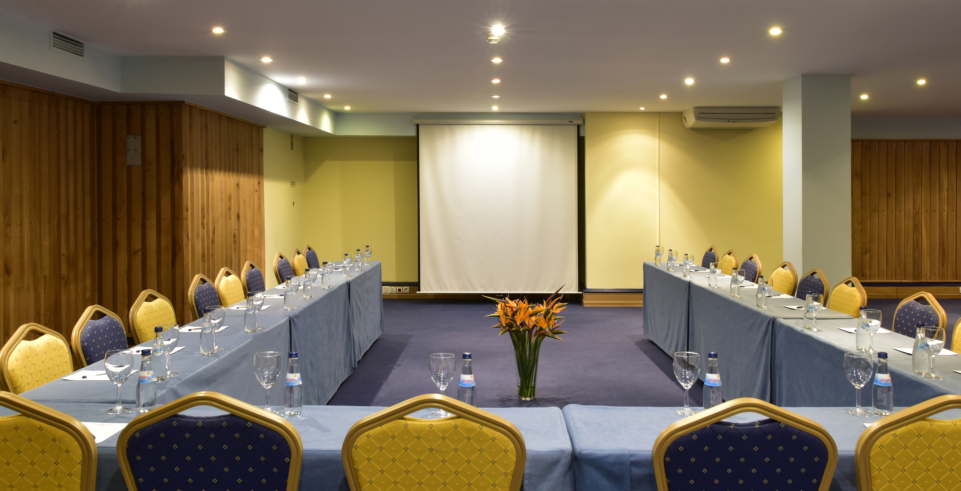 Le Pestana Viking hôtel 4 étoiles à Alvor dispose d'une salle de réunion avec plusieurs chaises et tables et un écran blanc