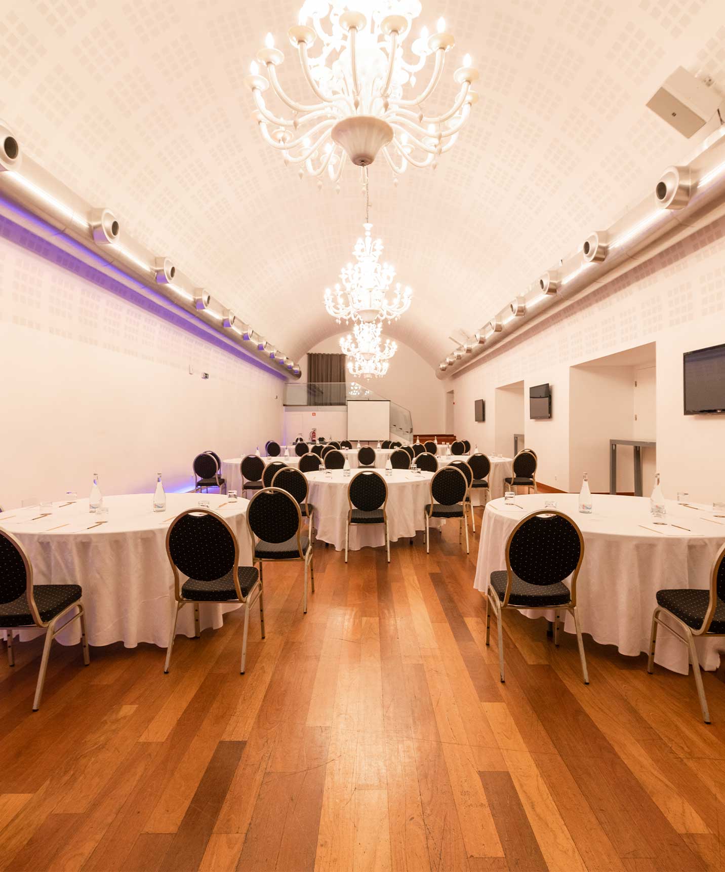 Salle de réunion et d'événements dans un hôtel avec spa et piscine, avec tables rondes et chaises pour plusieurs personnes