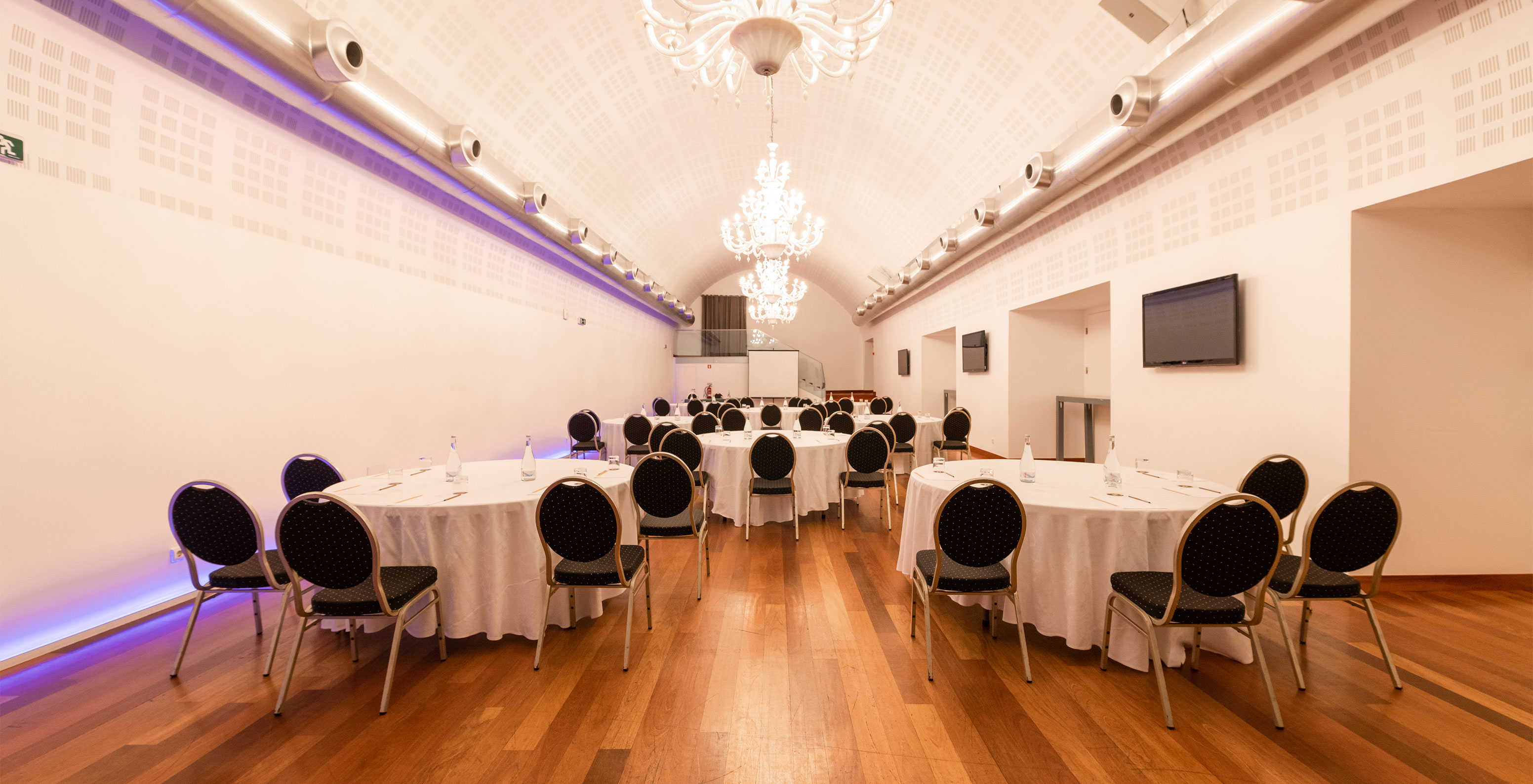 Salle de réunion et d'événements dans un hôtel avec spa et piscine, avec tables rondes et chaises pour plusieurs personnes