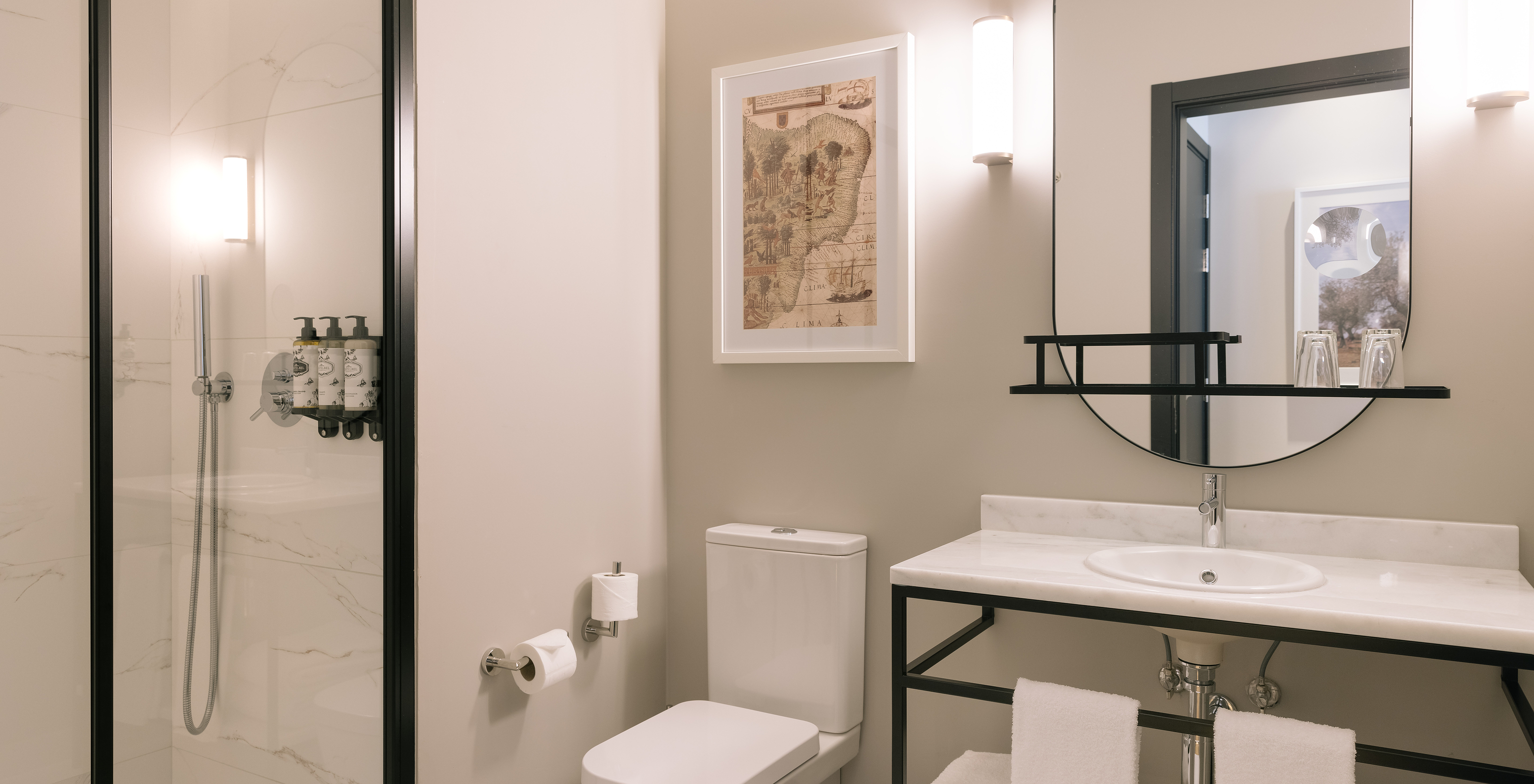 La Suite Familiale du Pestana Rua Augusta Lisboa a une salle de bain avec lavabo, miroir, toilettes et serviettes blanches