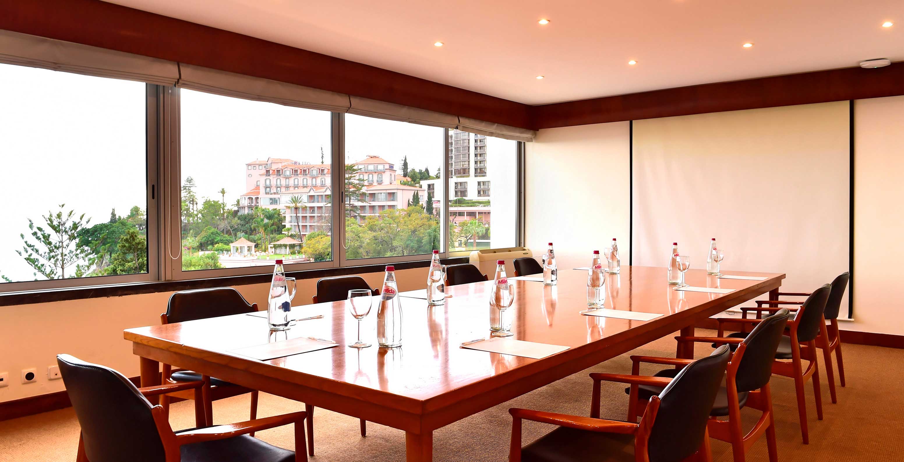 Le Pestana Carlton Madeira, un hôtel au centre de Funchal face à la mer, a une salle d'événements avec une table de chaises