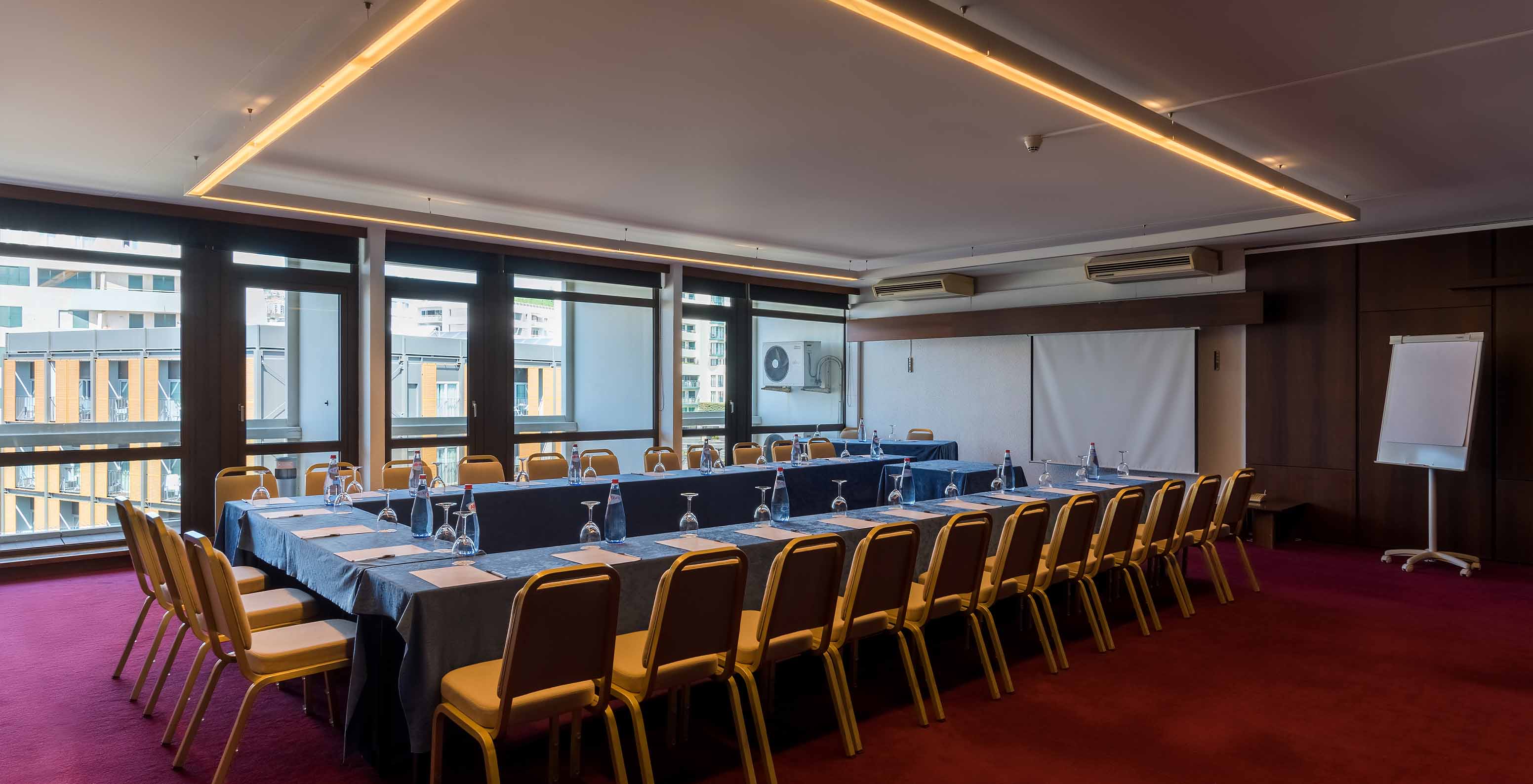 Salle de réunion du Pestana Casino Park avec une grande table, entourée de chaises et un tableau blanc en arrière-plan