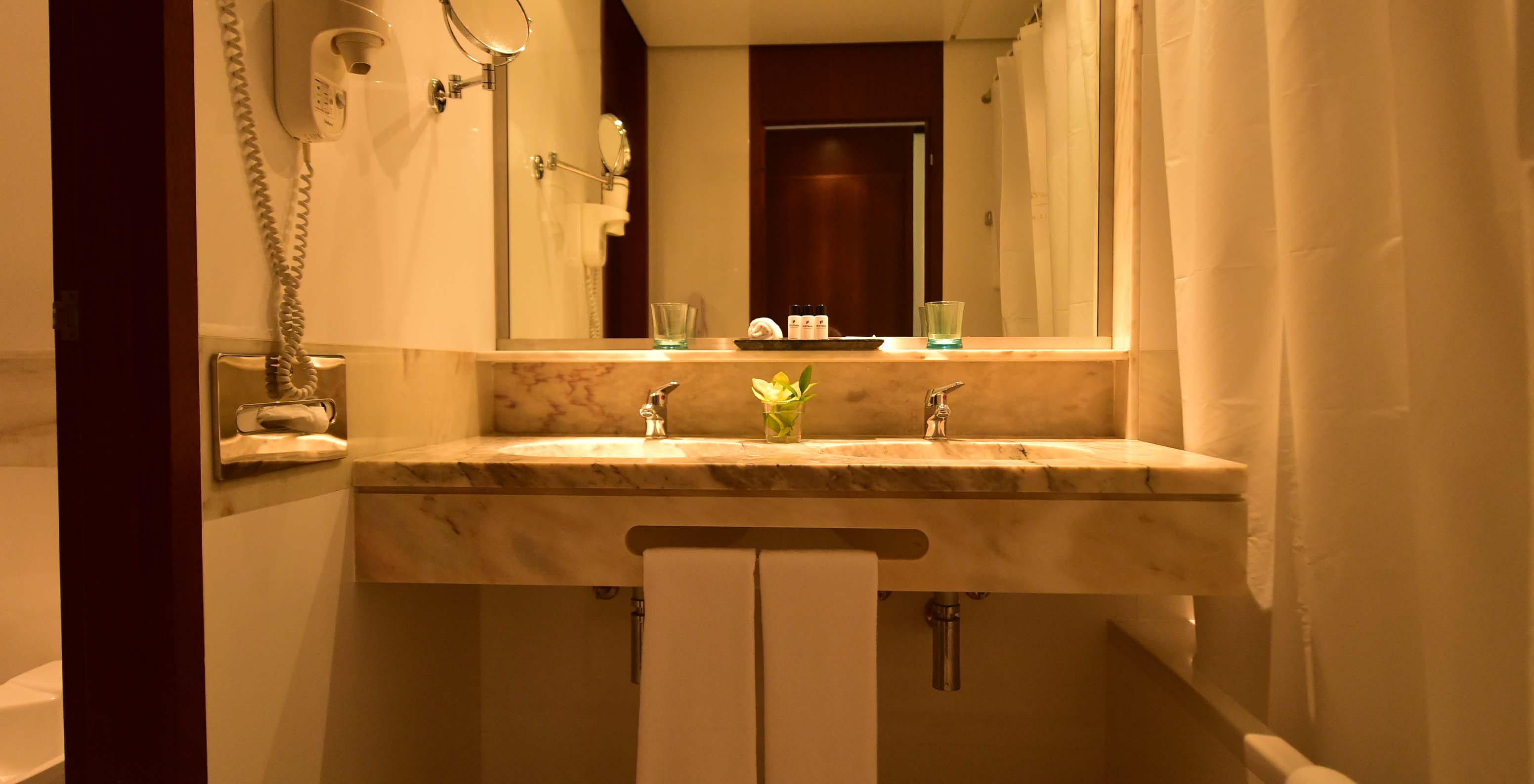 Le Classique Vue Jardin du Pestana Casino Park a une salle de bains avec lavabo en marbre, baignoire et sèche-cheveux