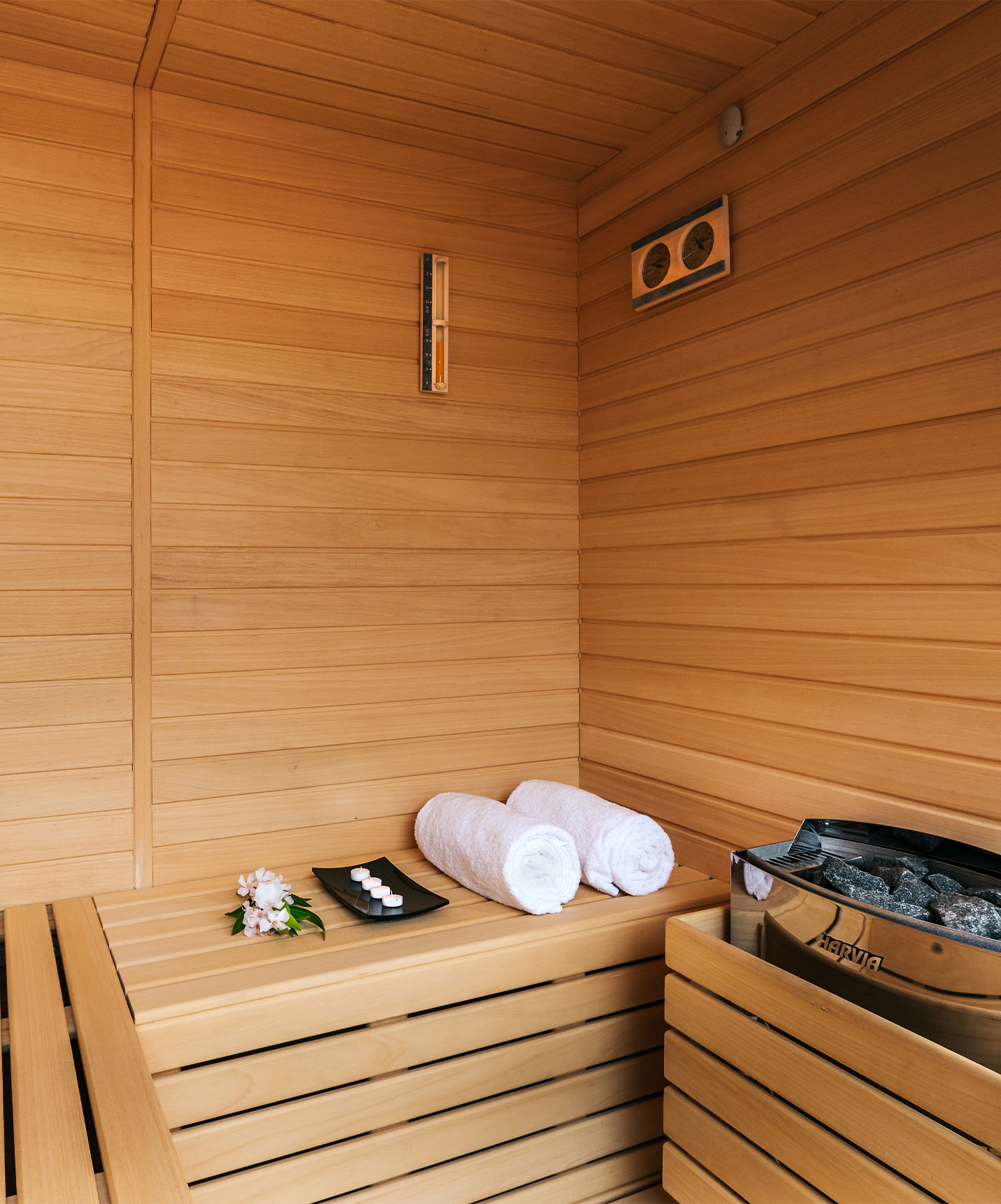 Espace sauna en bois avec deux serviettes et des bancs où vous pouvez vous reposer et profiter du traitement