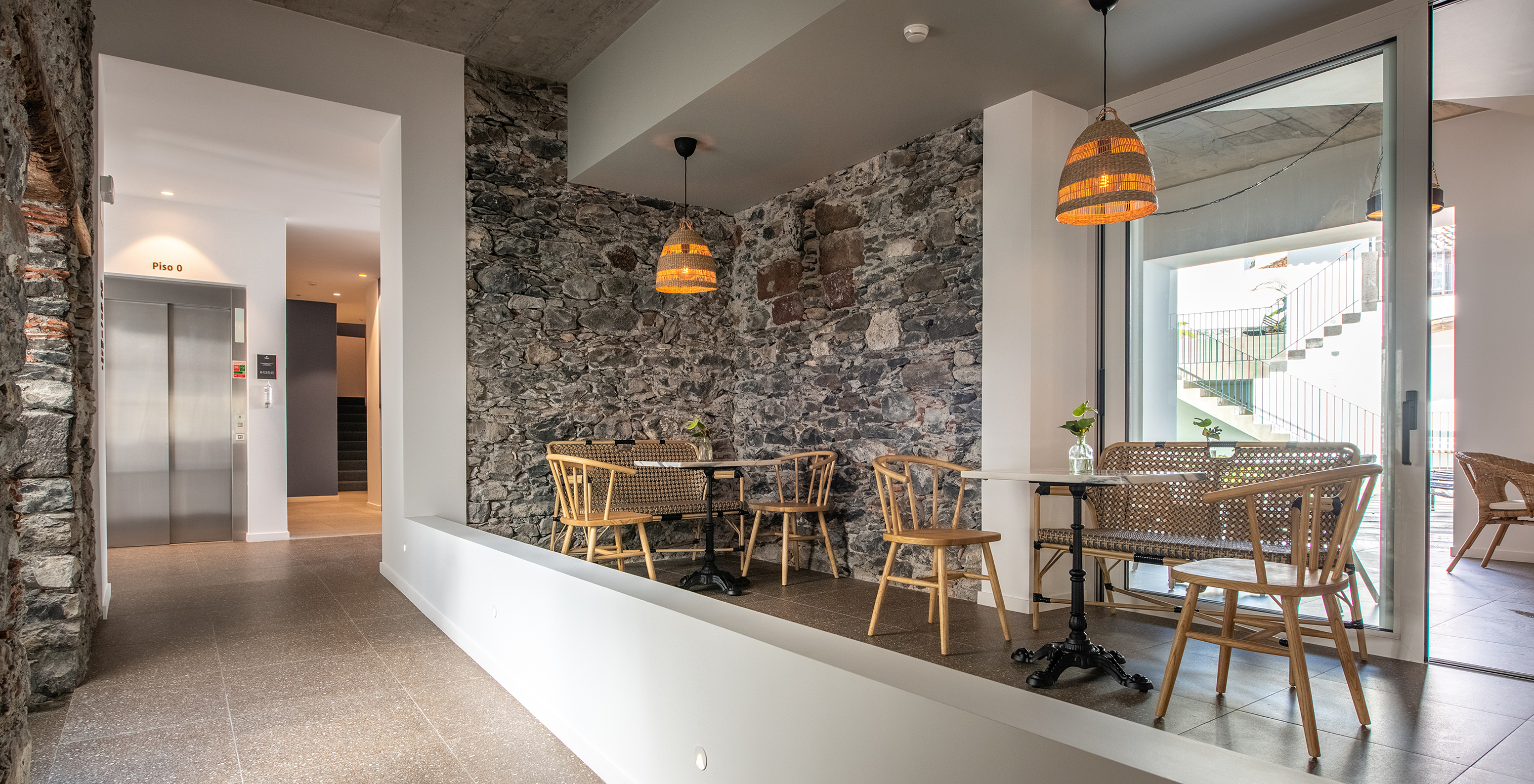 Intérieur d'un hôtel boutique avec terrasse et couloir avec ascenseur au fond