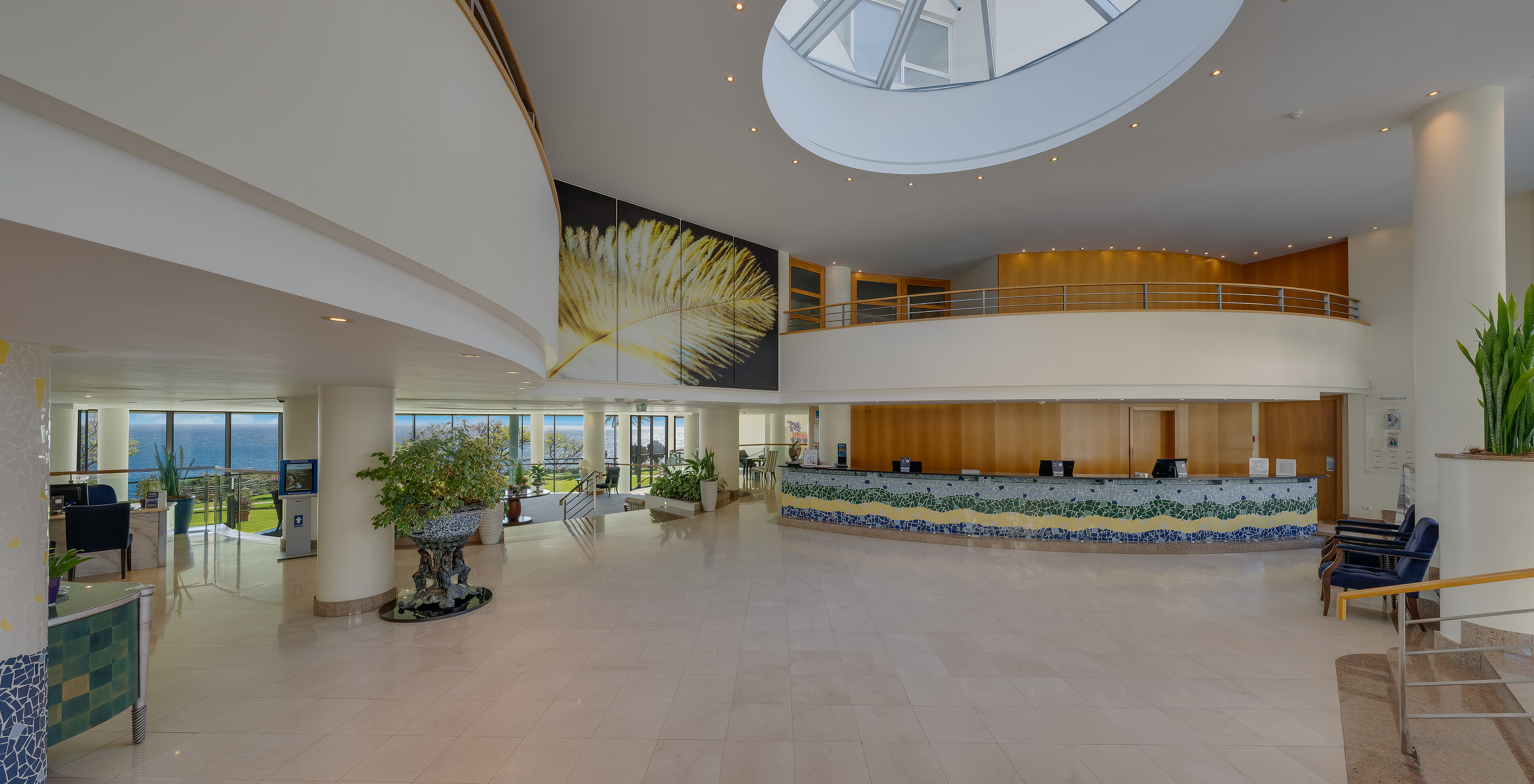 Pestana Grand, hôtel avec spa et piscine, en face de la mer, a une réception spacieuse, avec lumière naturelle et chaises