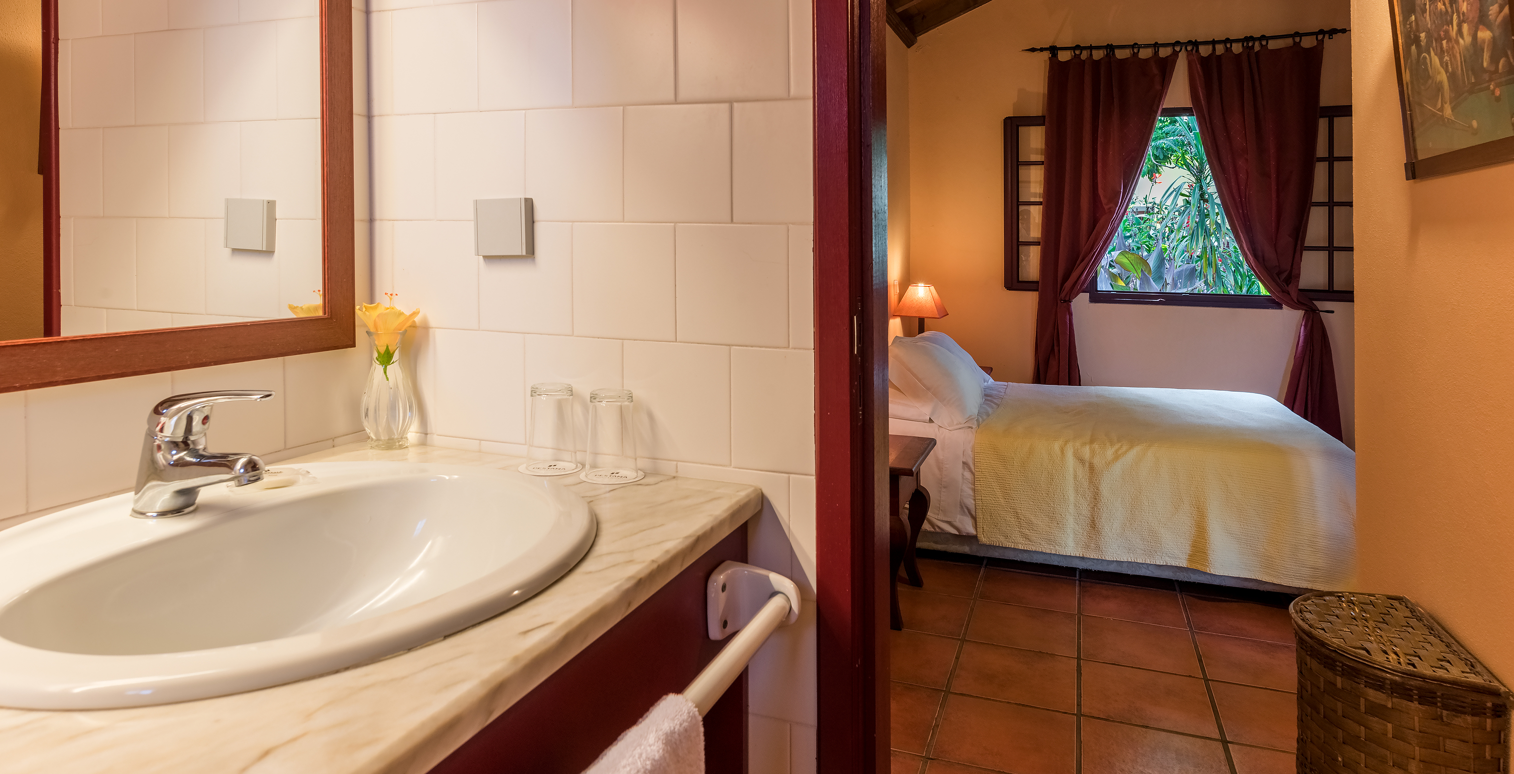 Les Villas du Pestana Quinta do Arco ont salle de bain avec lavabo et la porte ouverte pour la chambre avec lit double