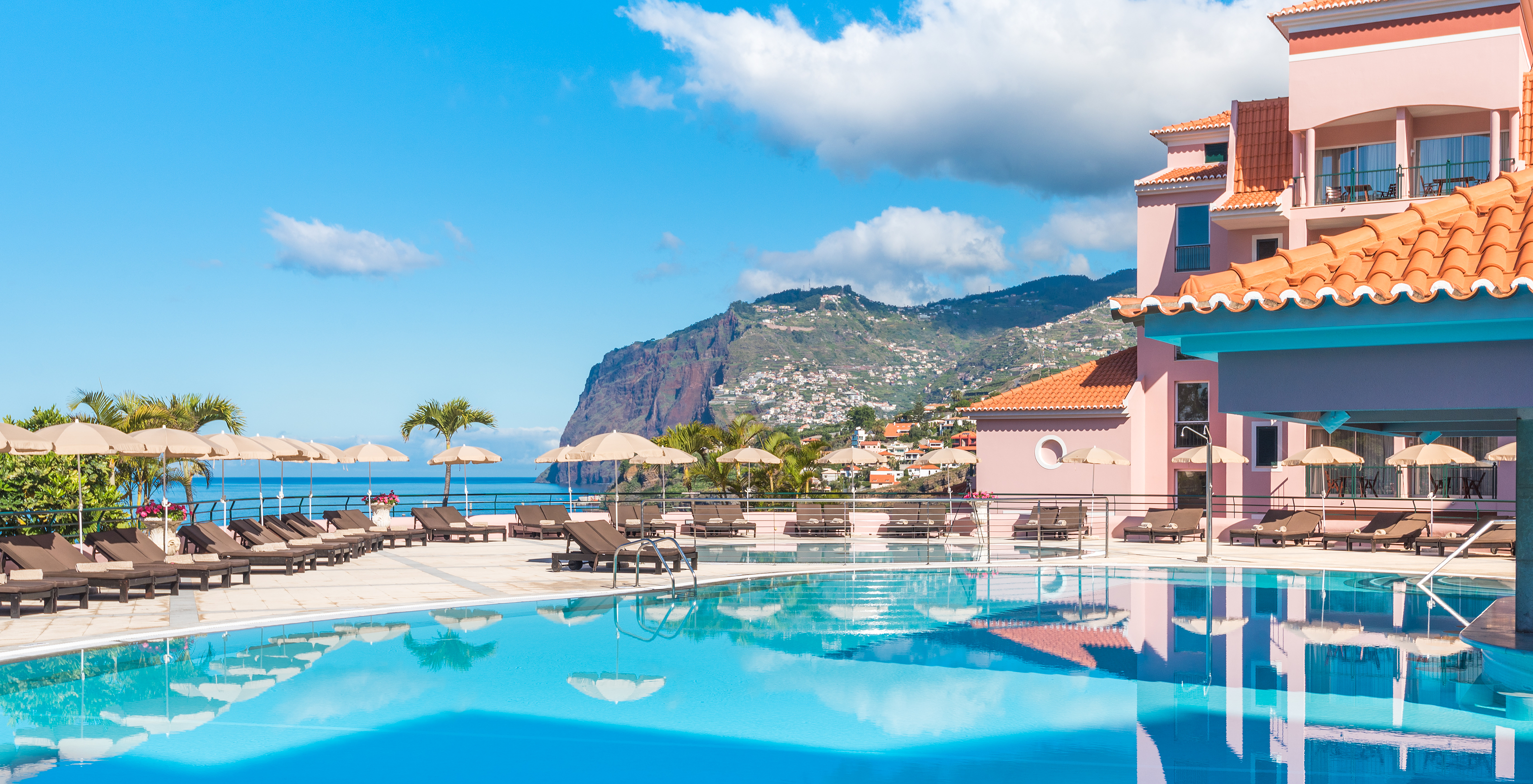 Le Pestana Royal All Inclusive, hôtel près de la plage, dispose d'une piscine extérieure bleue avec chaises longues