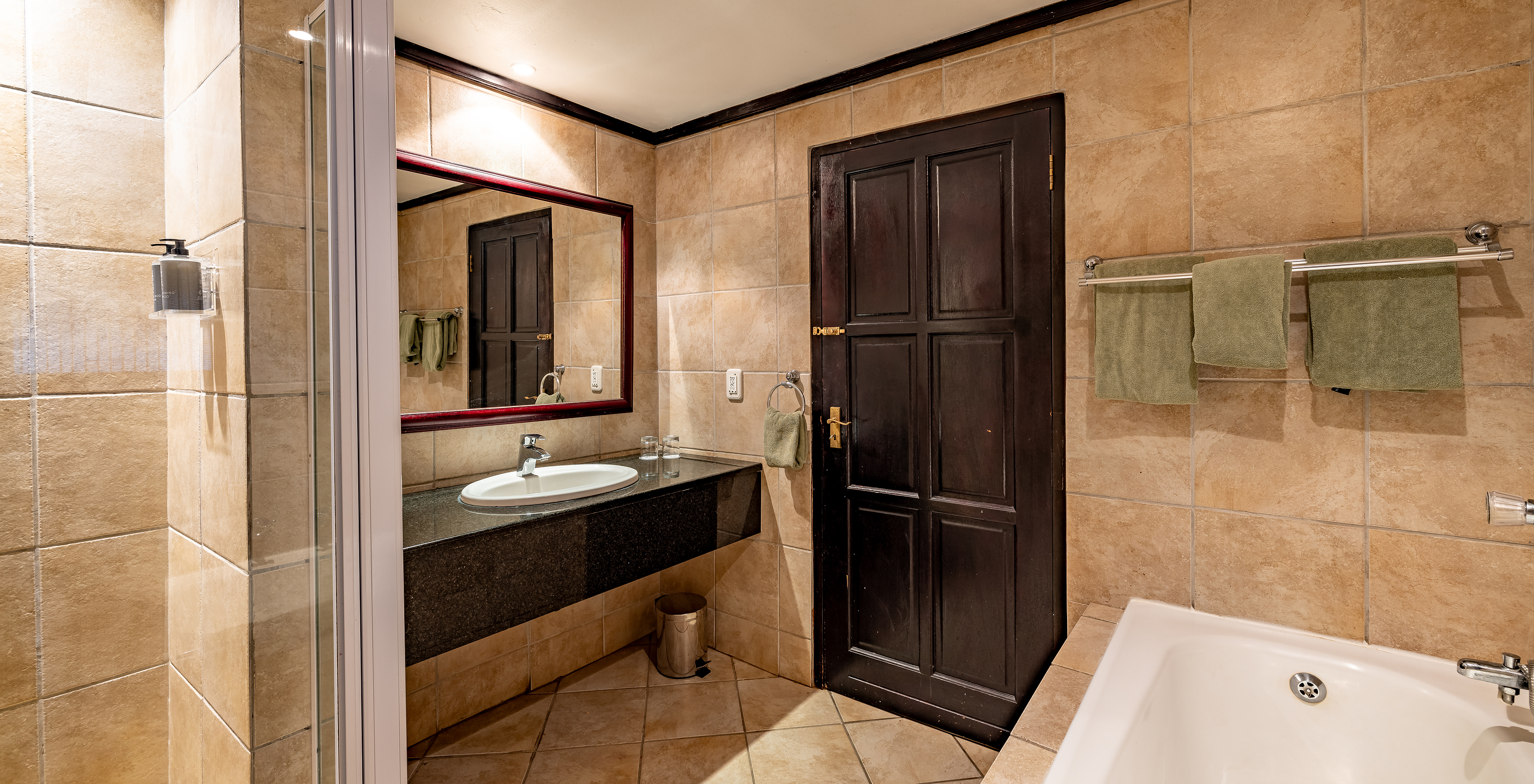 La Premium Room du Pestana Kruger Lodge a une salle de bain avec baignoire douche et lavabo avec miroir